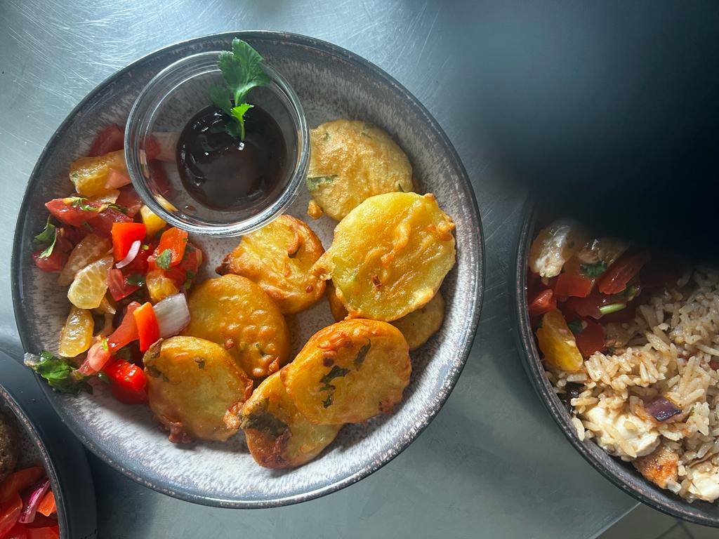 Frittierte Snacks mit Sauce und Salat auf einem Teller.