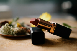 Lippenstift auf dem Tisch mit floralen Akzenten.