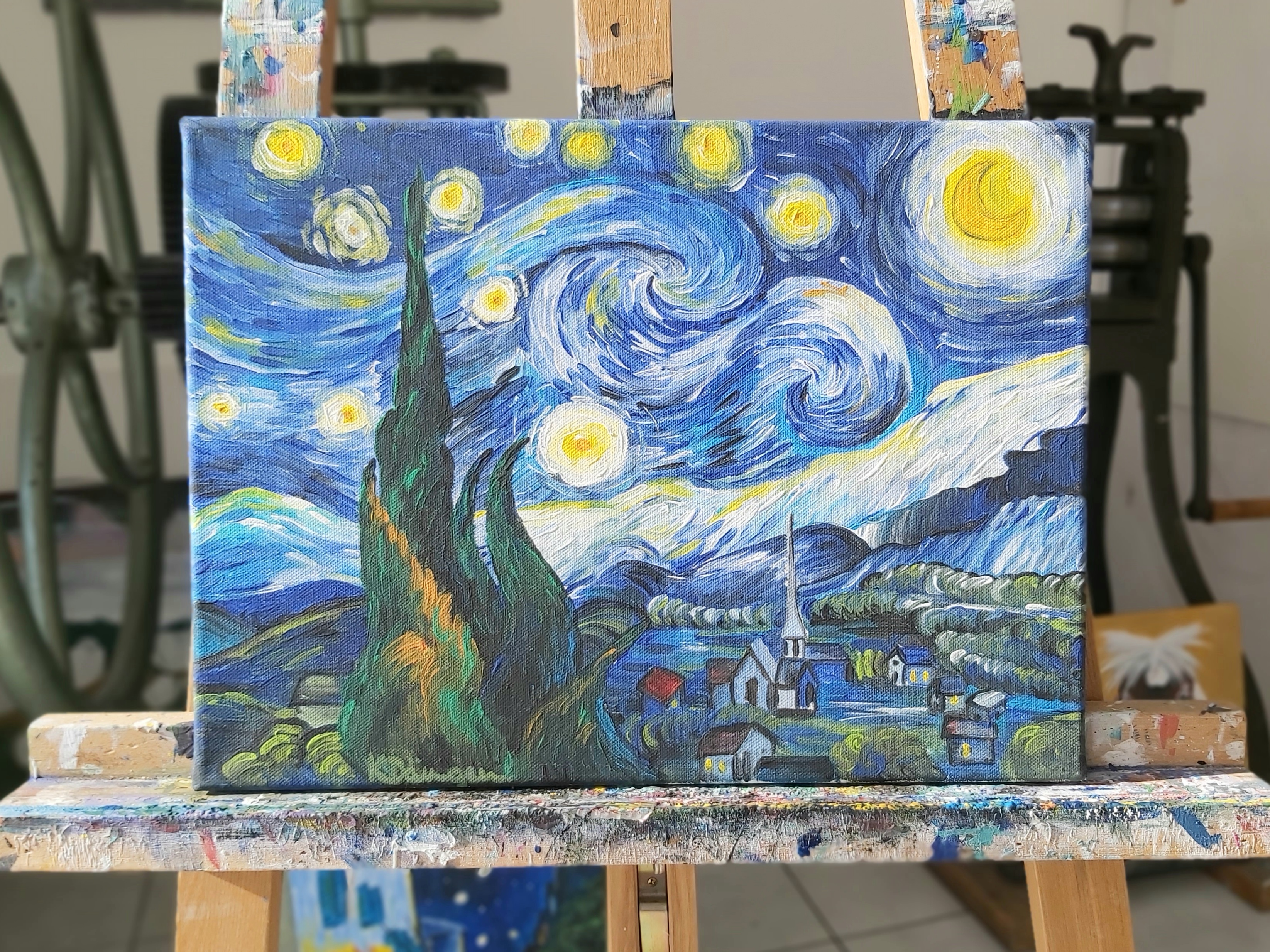 A painting depicts swirling stars over a village.