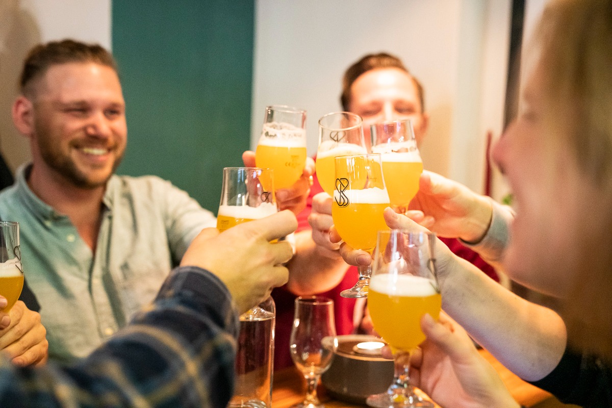 Glasses of beer are toasted at a ceremony.