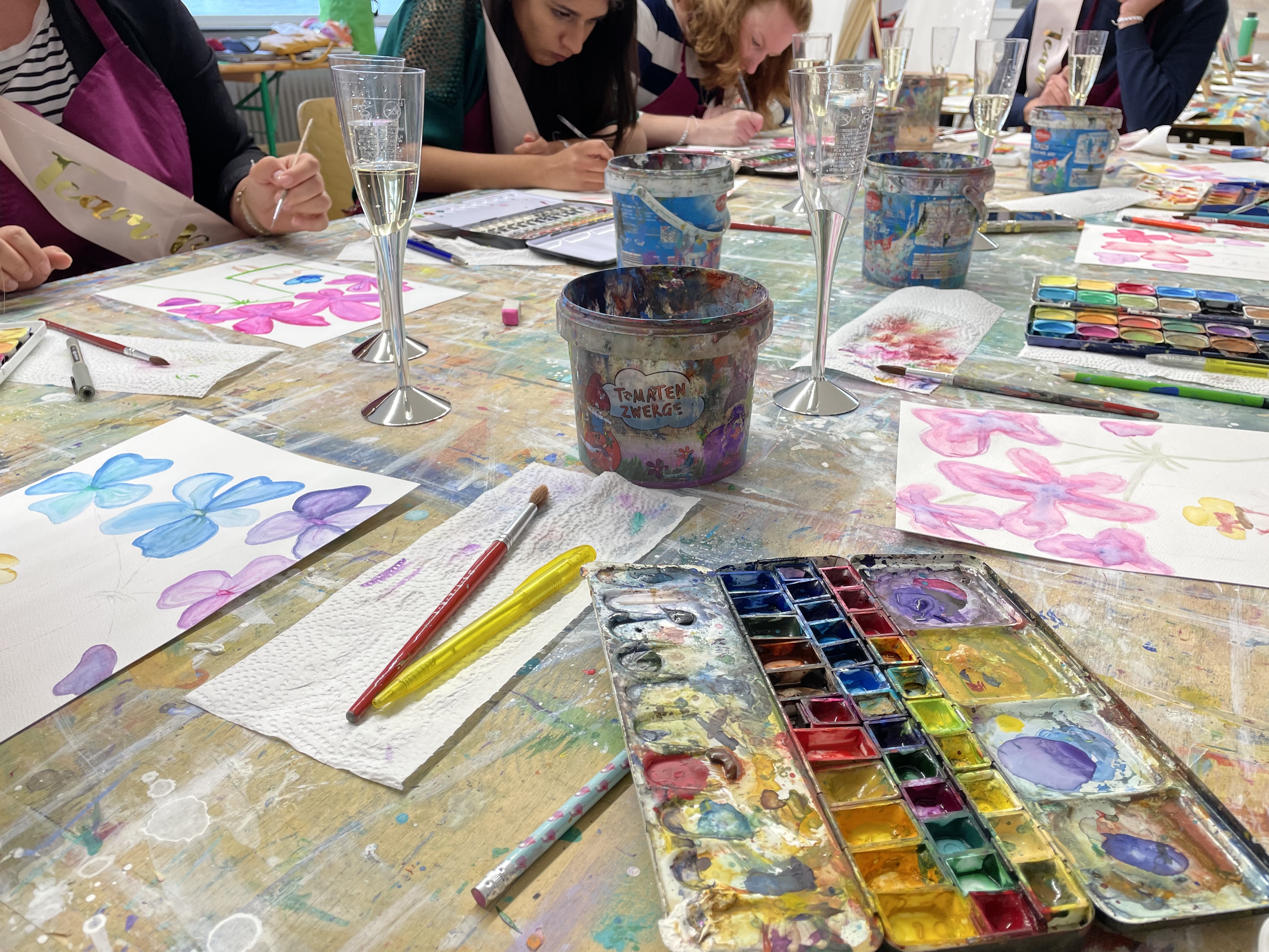 Aquarellfarben werden auf Papier verwendet, um Blumen zu malen.