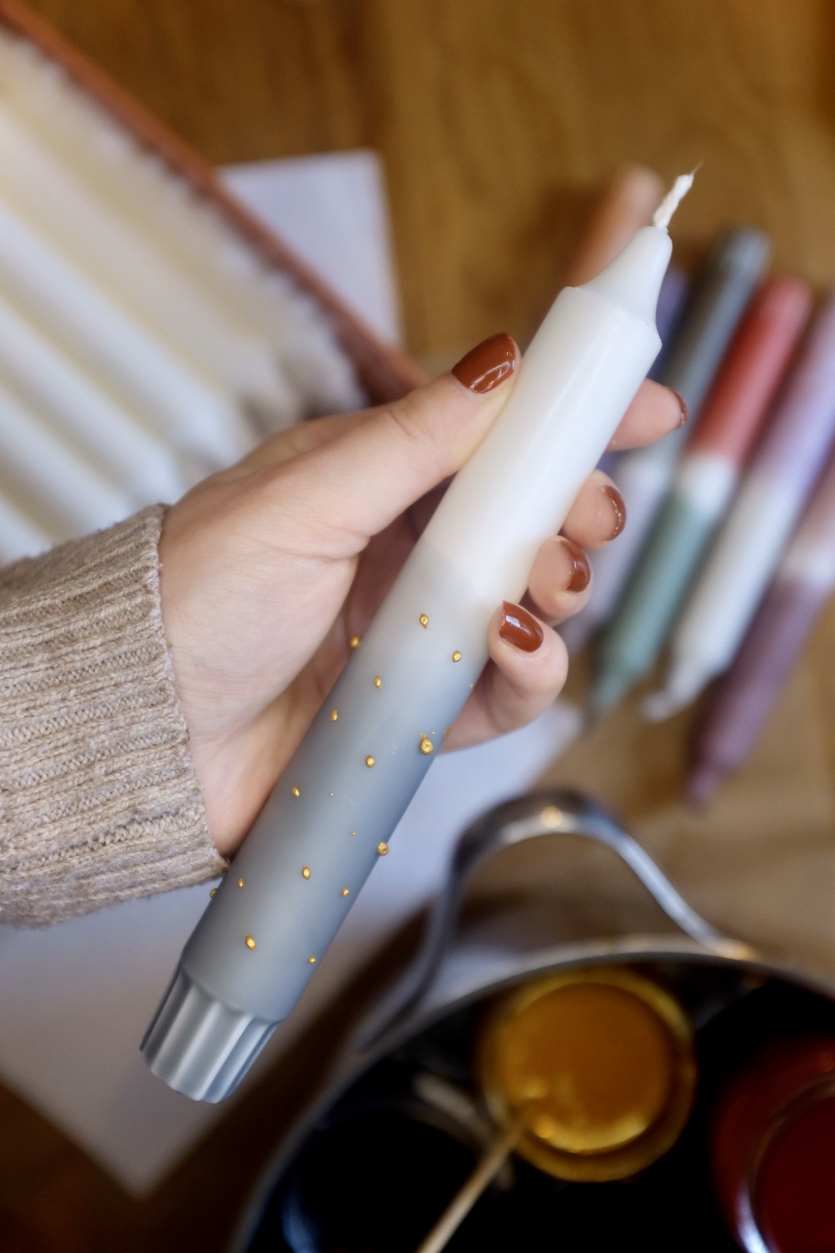 Pen in hand paints on a smooth surface, colors in the background