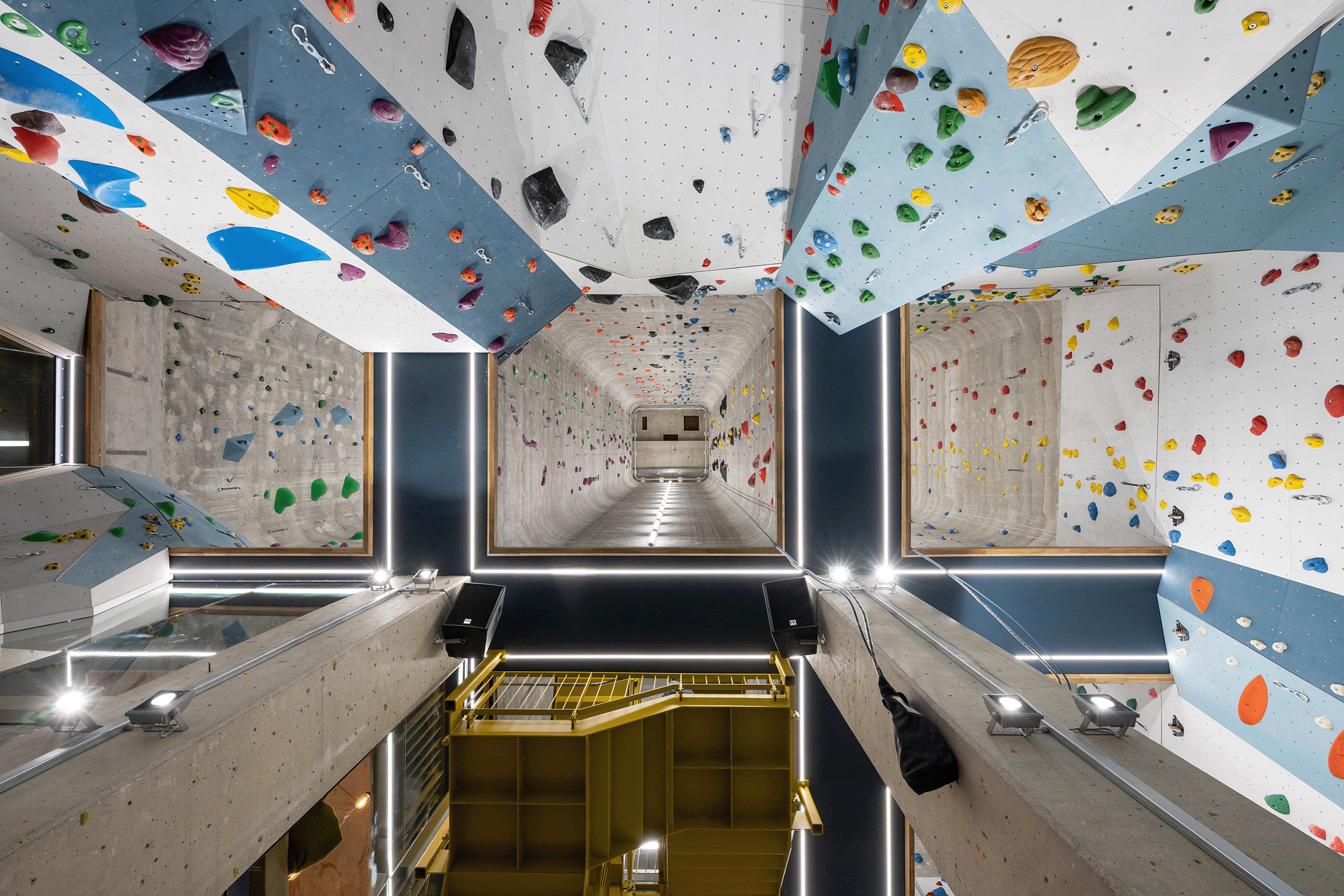 Kletterwand in Halle; Kletterer bewegt sich vertikal in der Höhe.