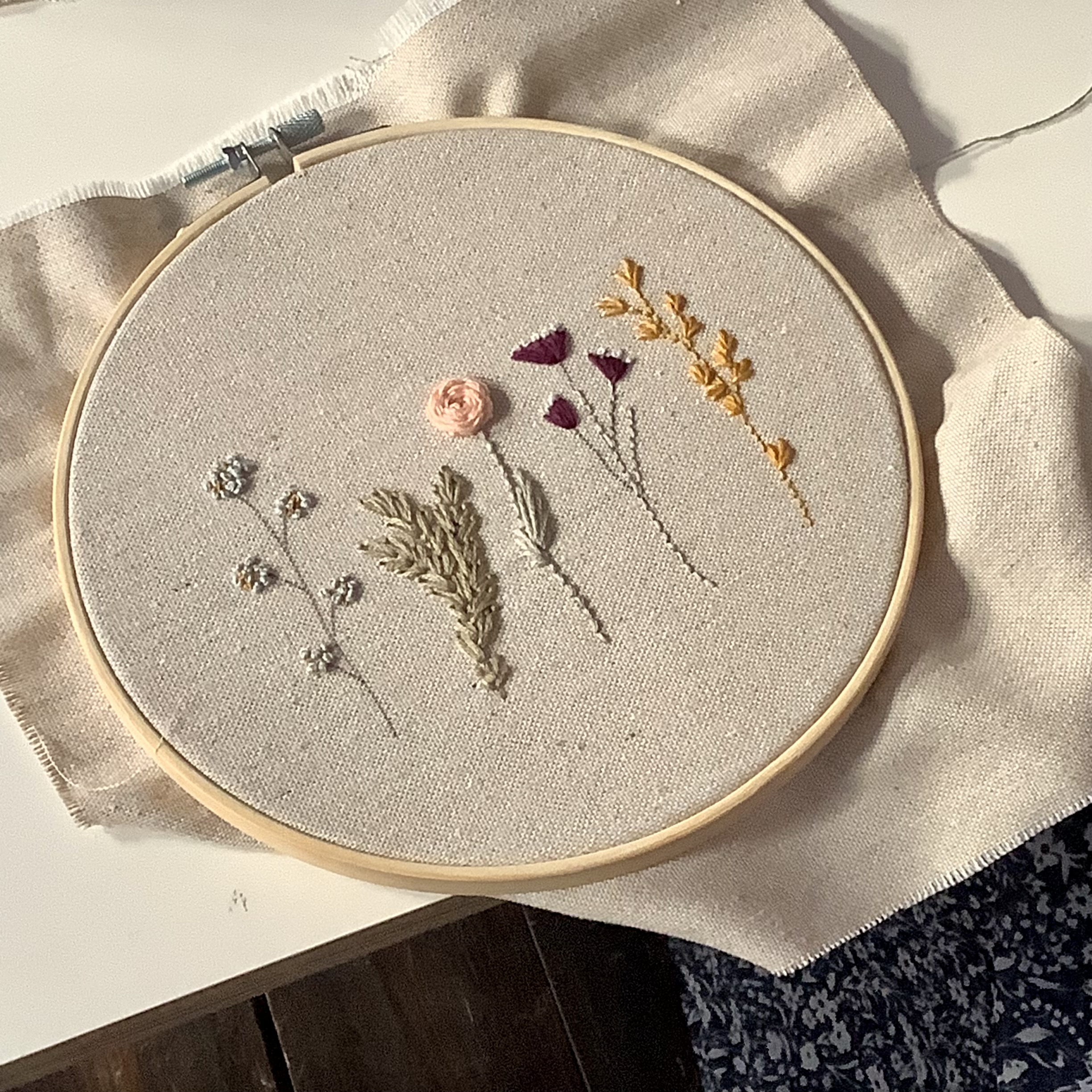 Stickrahmen mit Blumenmustern auf Stoff.