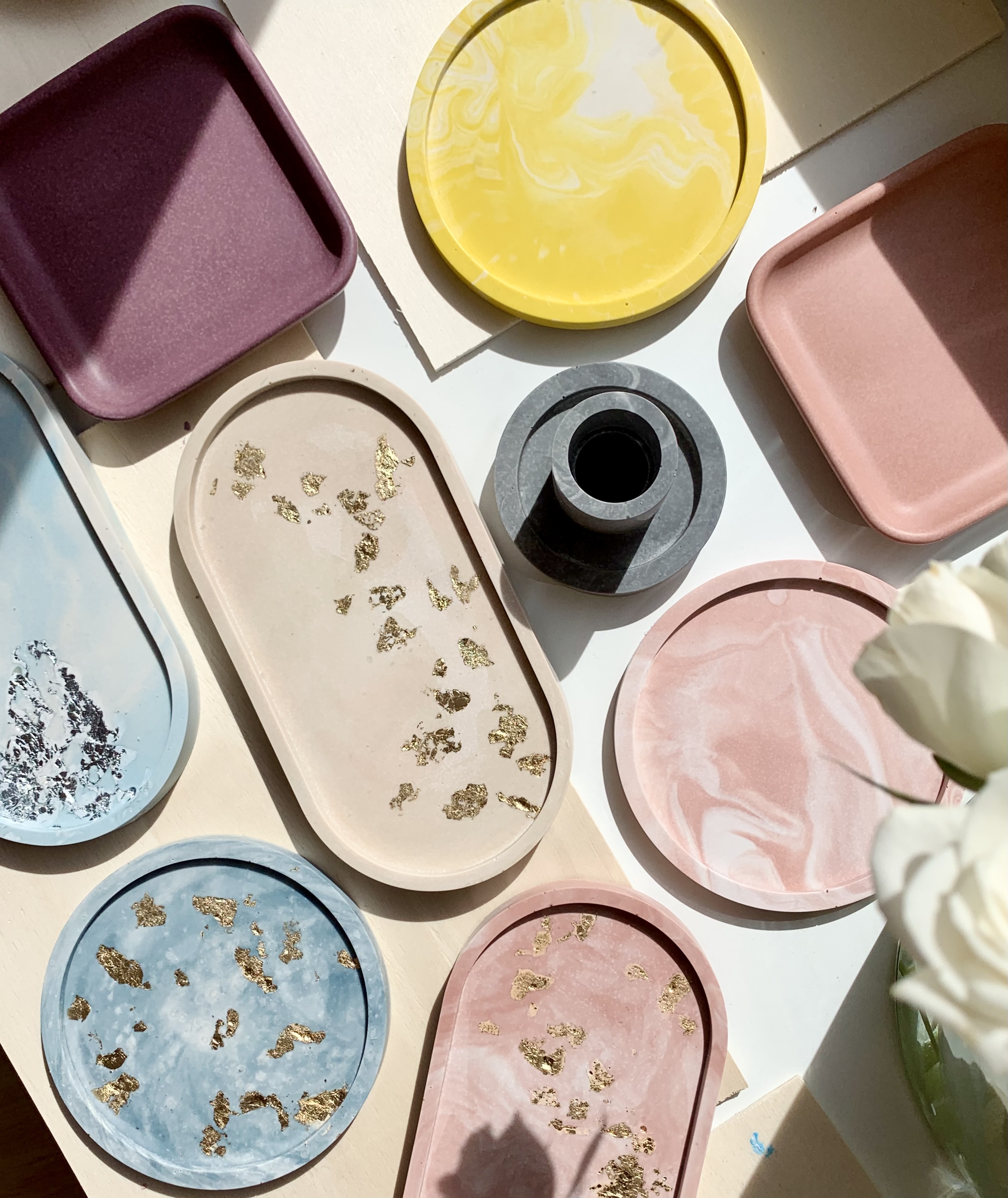 Bunte Tabletts liegen auf einem Tisch mit Blumen.