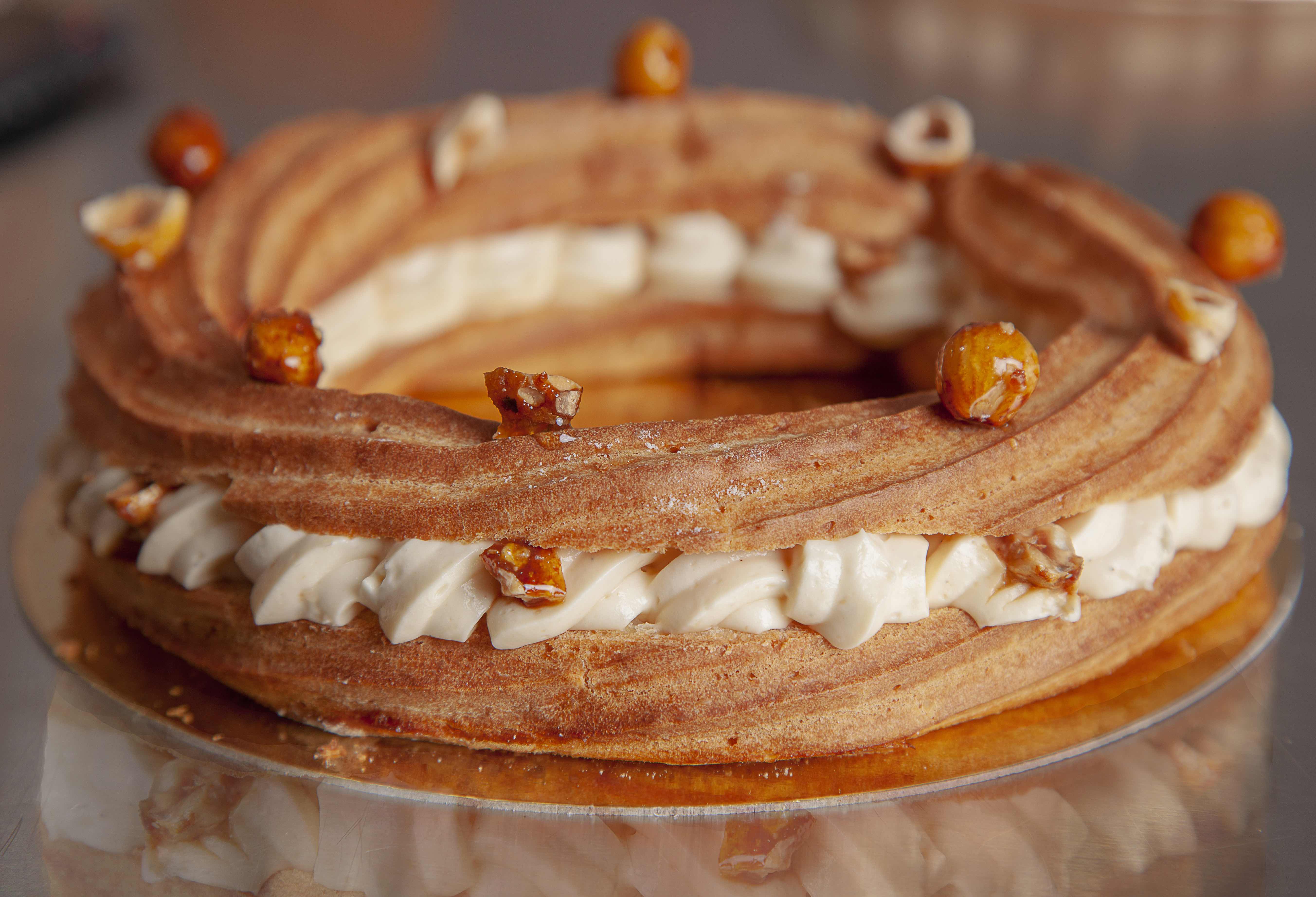 Kremschicht-Torte mit Nüssen auf goldenem Teller präsentiert.