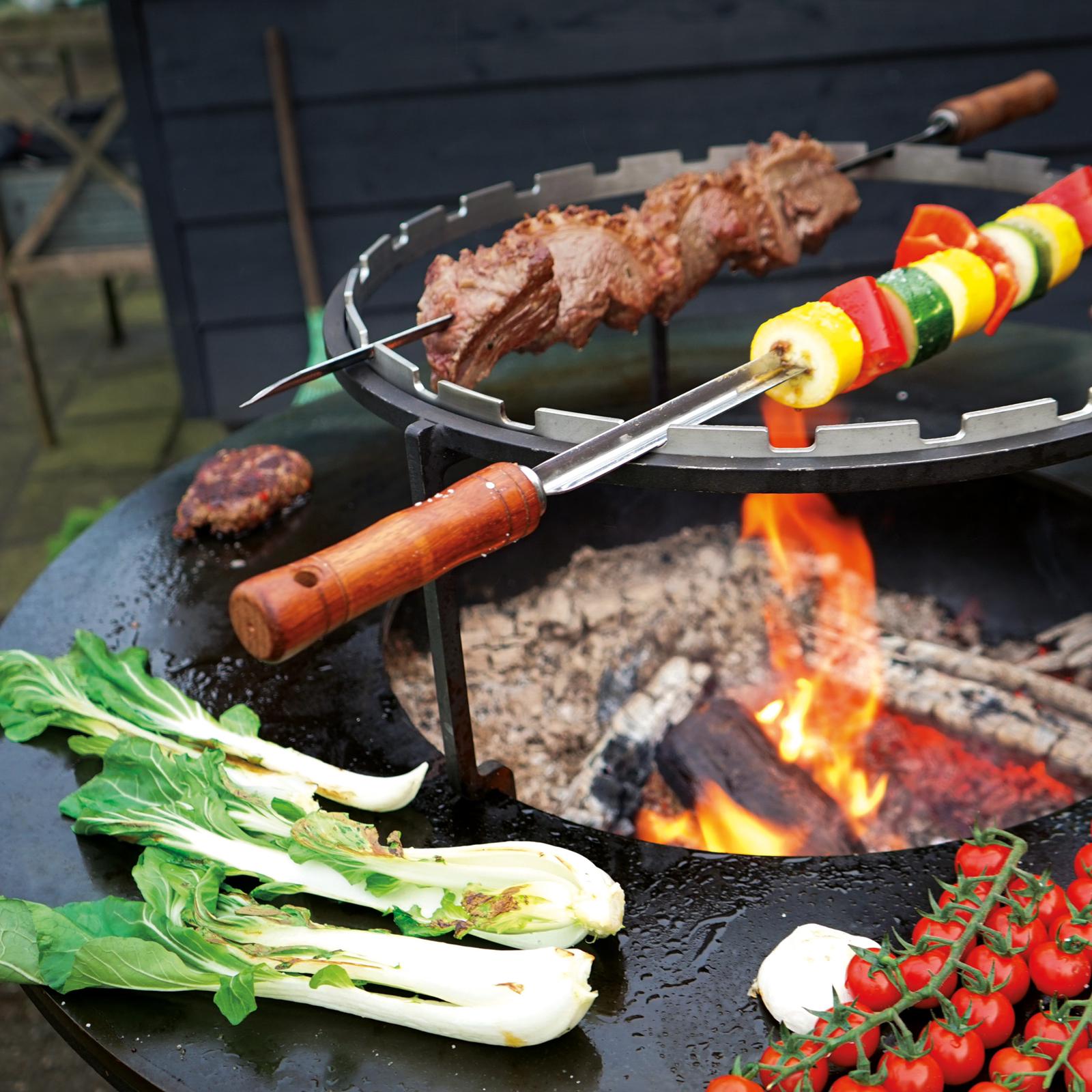 Fleisch und Gemüse grillen über offenem Feuer im Freien.