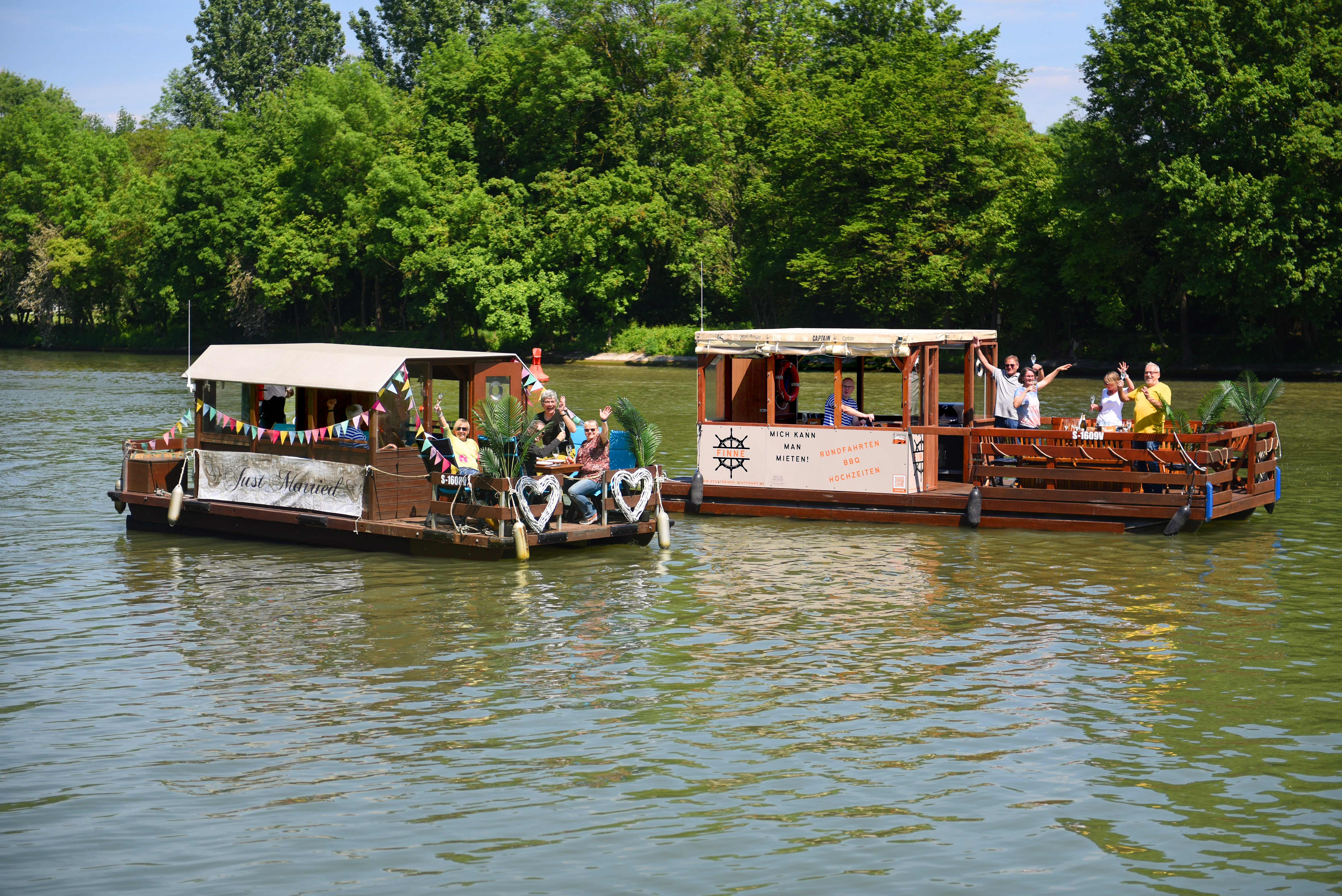 Two floating boats are happily partying on a river.