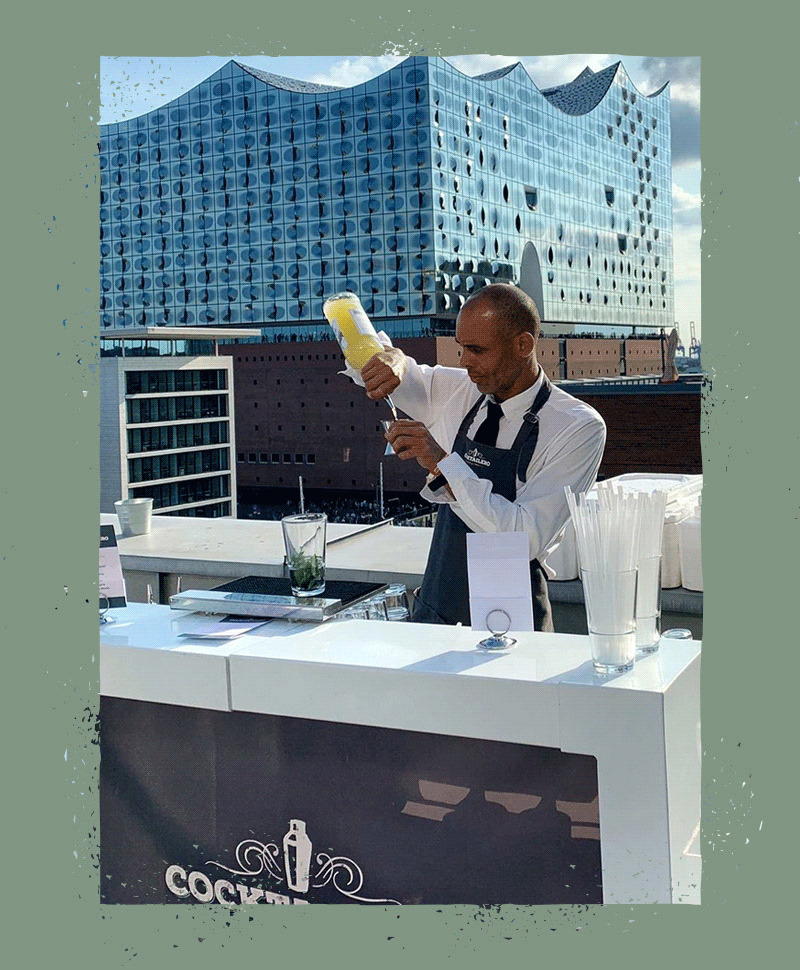 Bartender mixes a cocktail on a roof terrace.