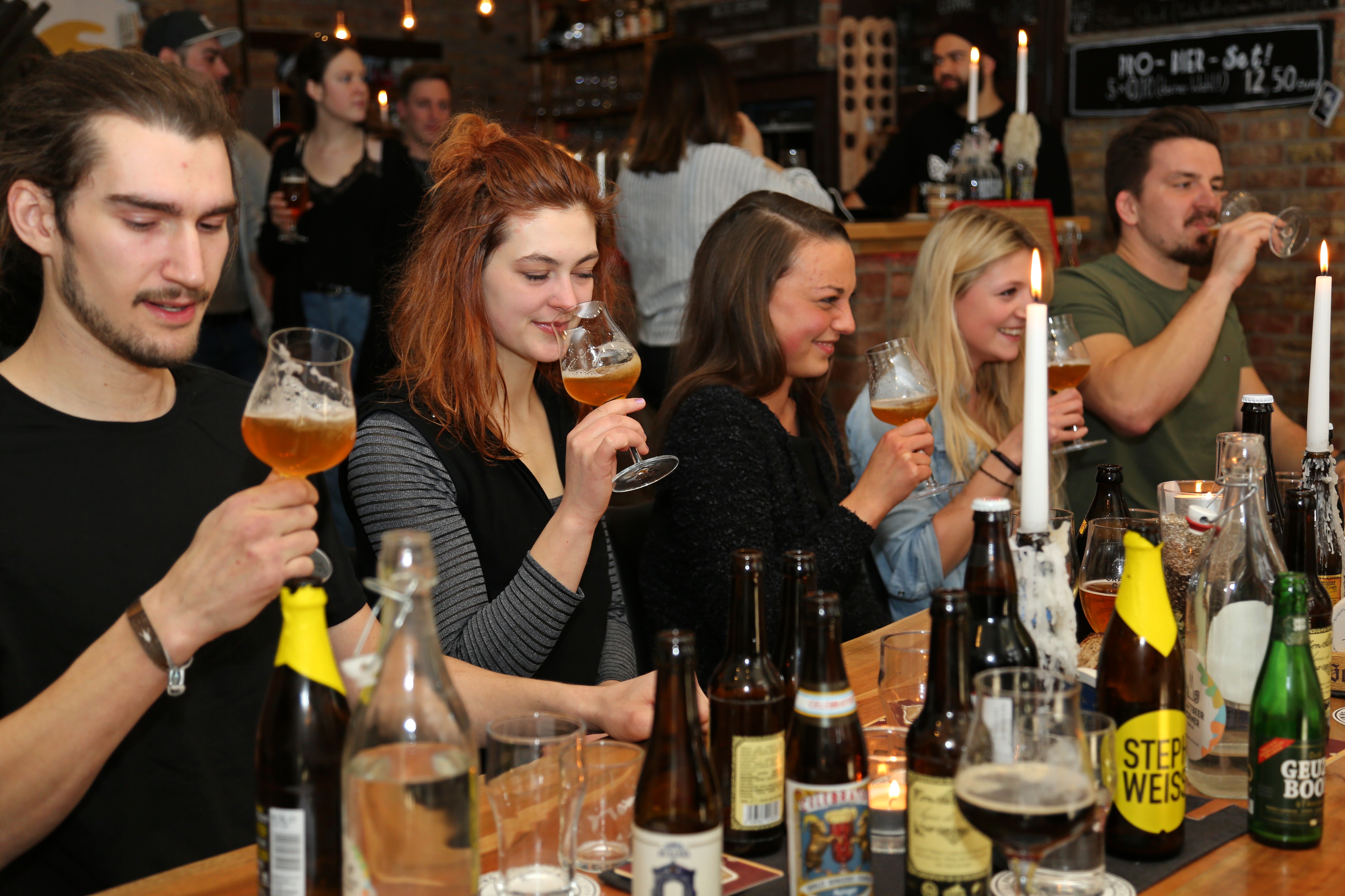 Gruppe von Menschen genießt Bier in einer gemütlichen Bar.