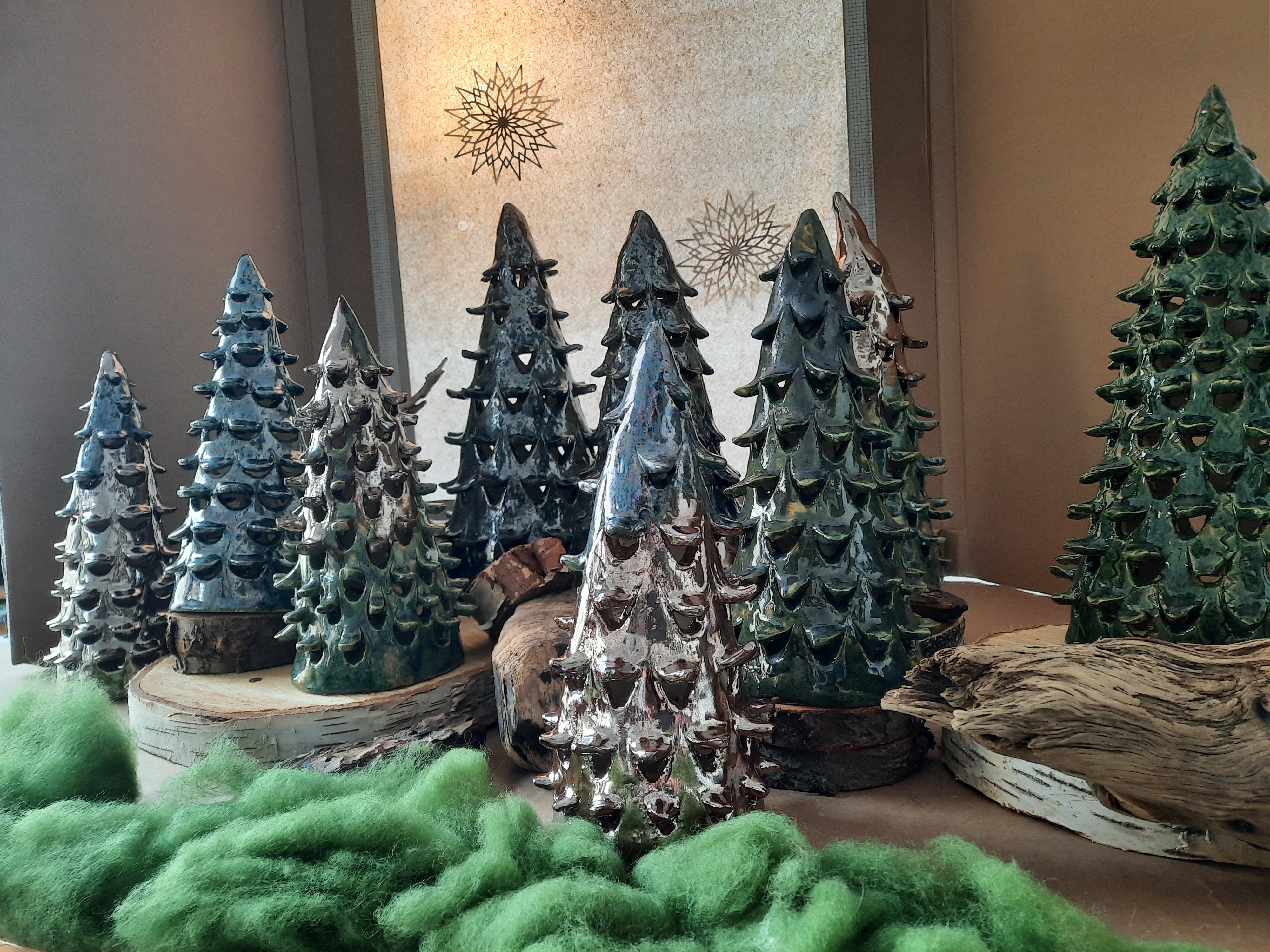 Ceramic trees stand on wooden discs with green felt-like materials.