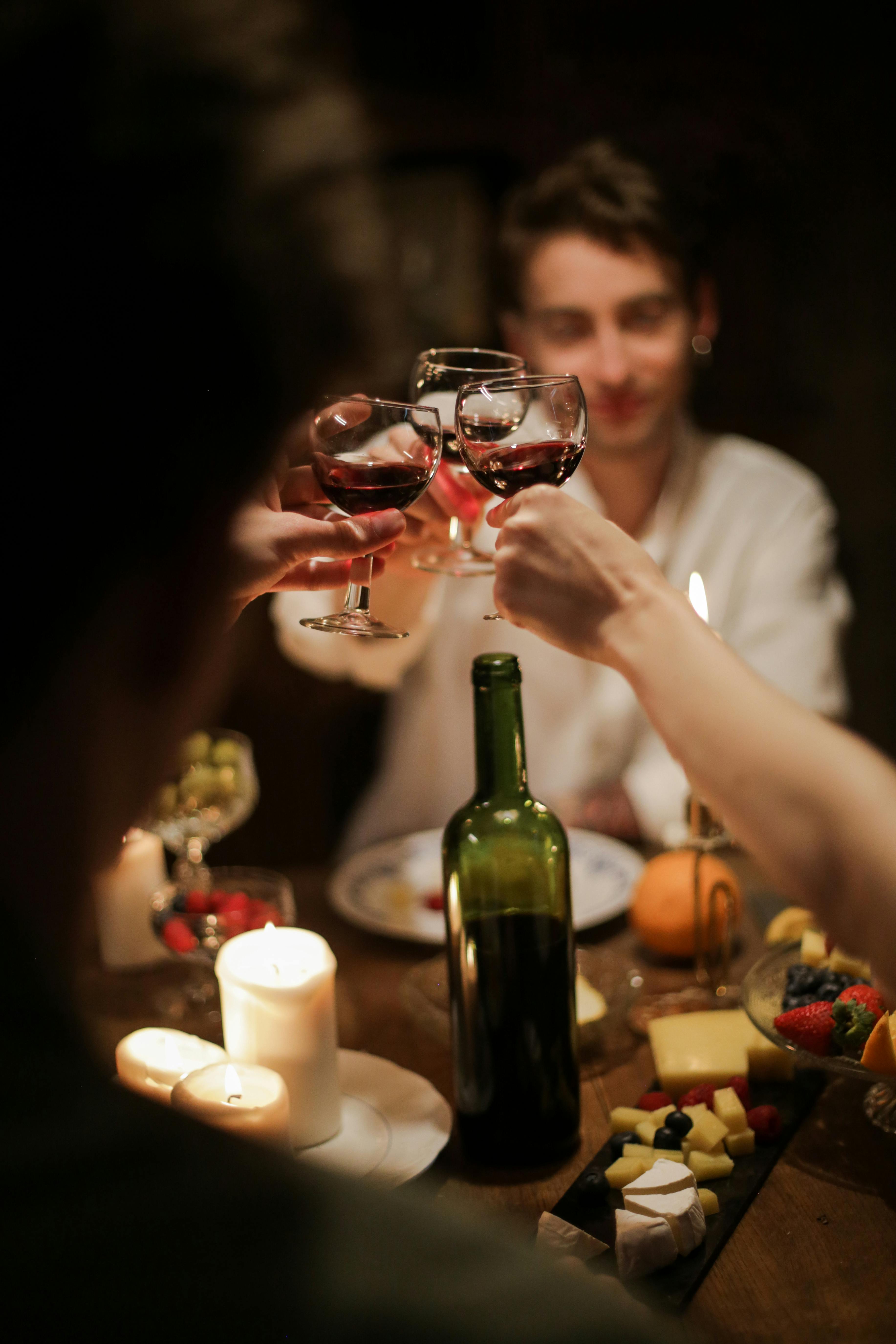 Gläser heben sich zum Anstoßen bei einem festlichen Abendessen.