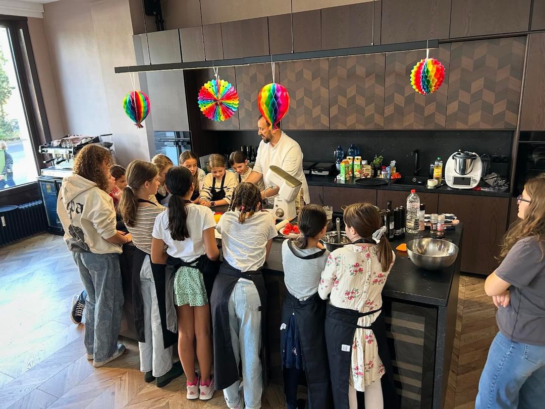 A group of girls cook together in a modern kitchen.