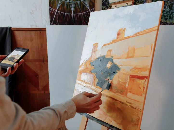 An artist paints a painting in a studio.