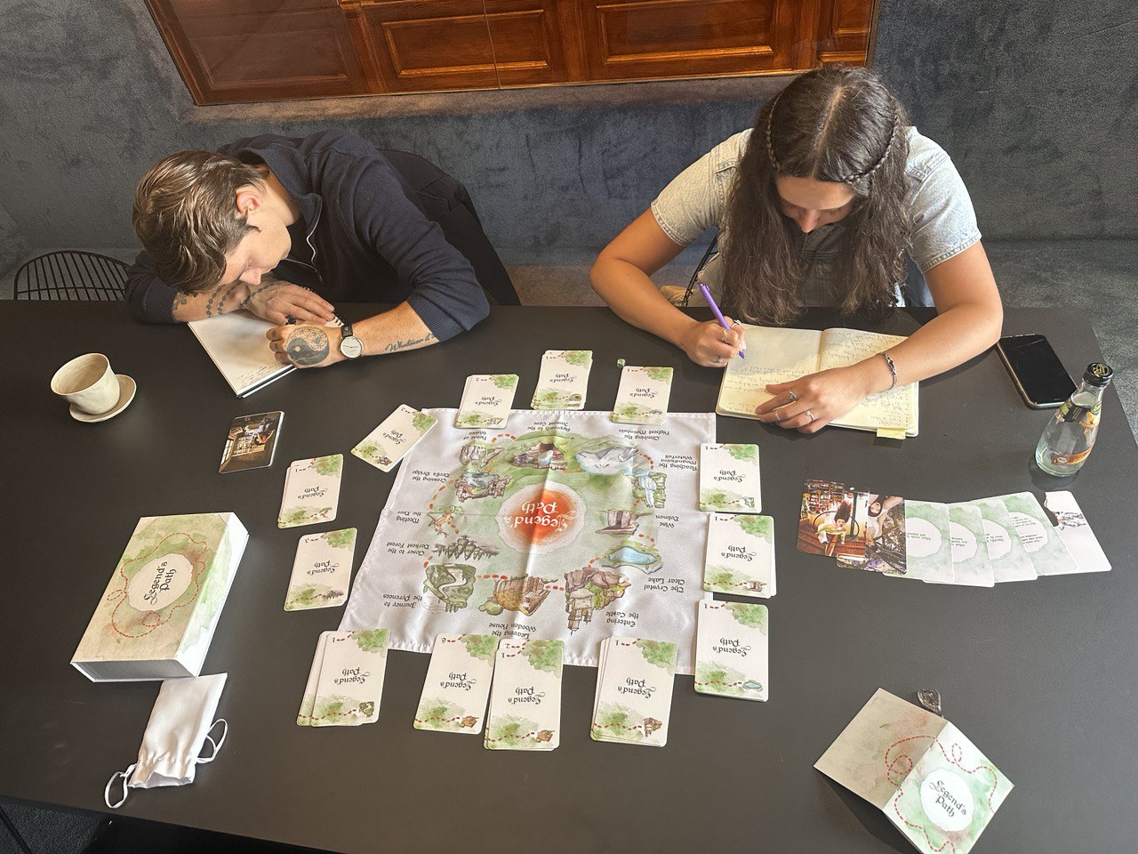 Two people are playing a board game at a table.
