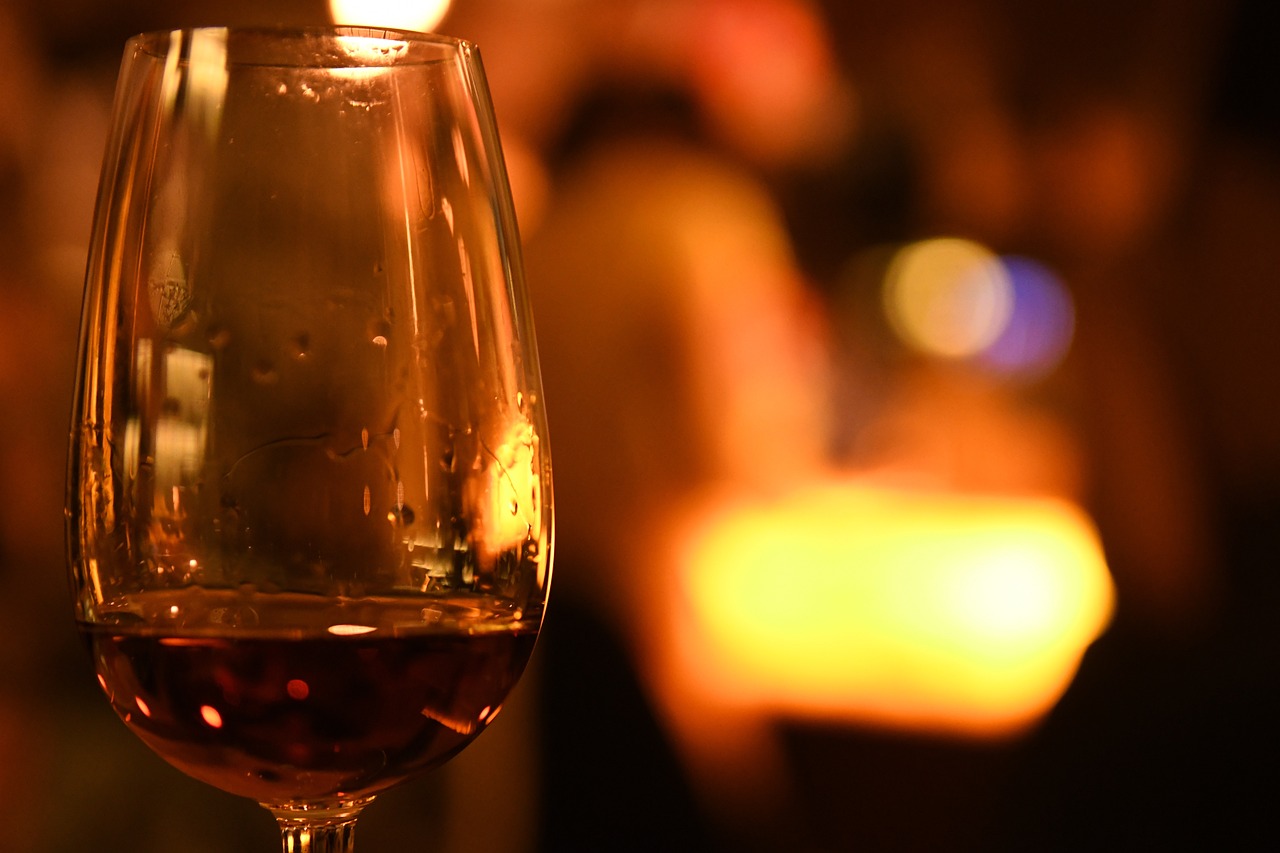 A wine glass is set against a blurry, warm background.