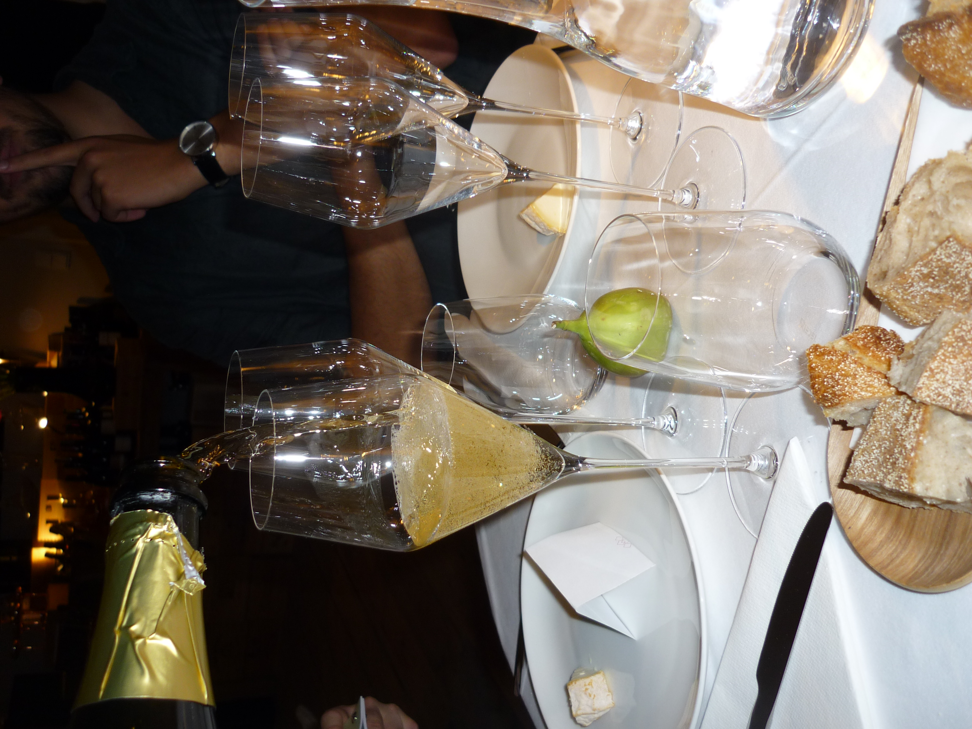 Sparkling wine is poured into glasses surrounded by guests.