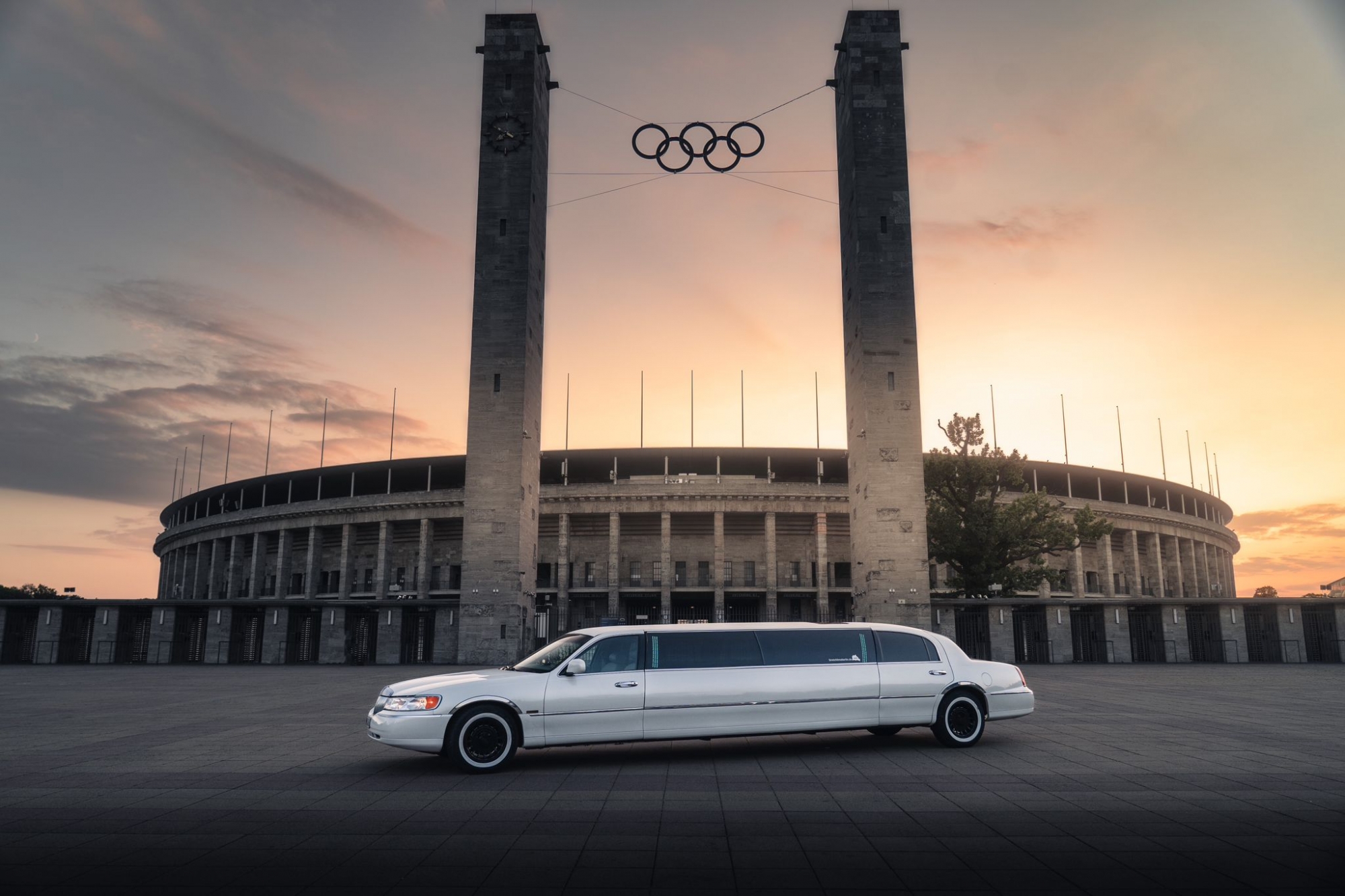 Weißes Stretchlimousinenfahrzeug parkt vor dem Olympiastadion.