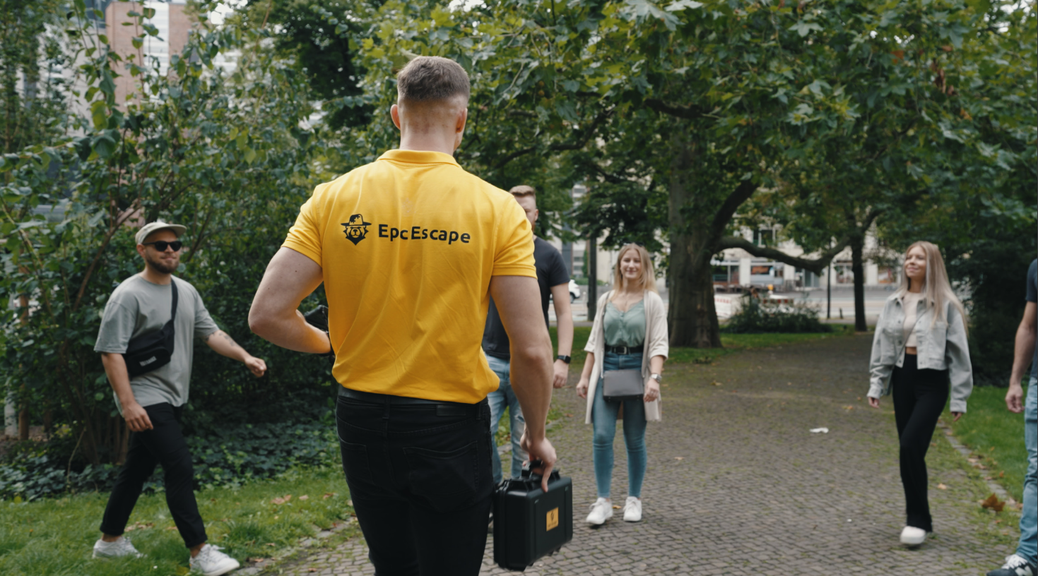 Person in yellow shirt leading group outdoors.