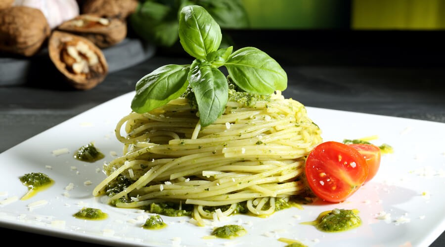 Pasta pesto, garnished with basil and tomato