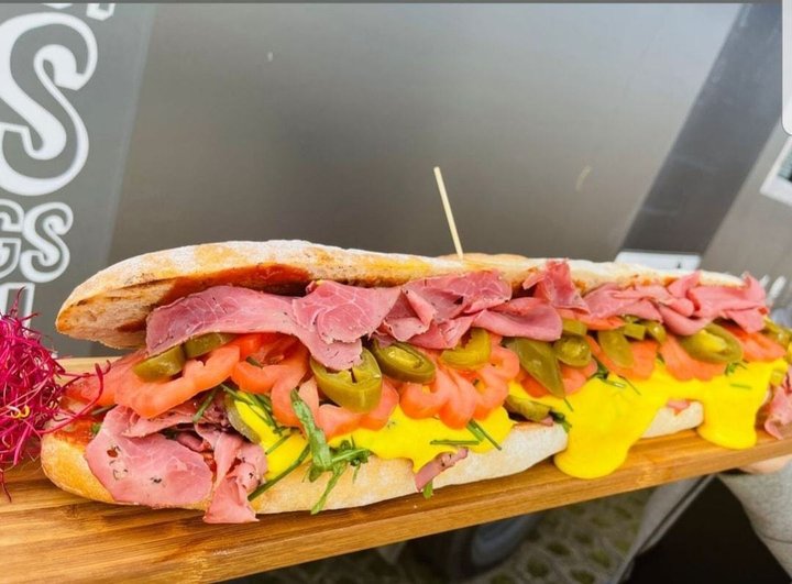 Ein Sandwich mit Sauce, Schinken und Chilis.
