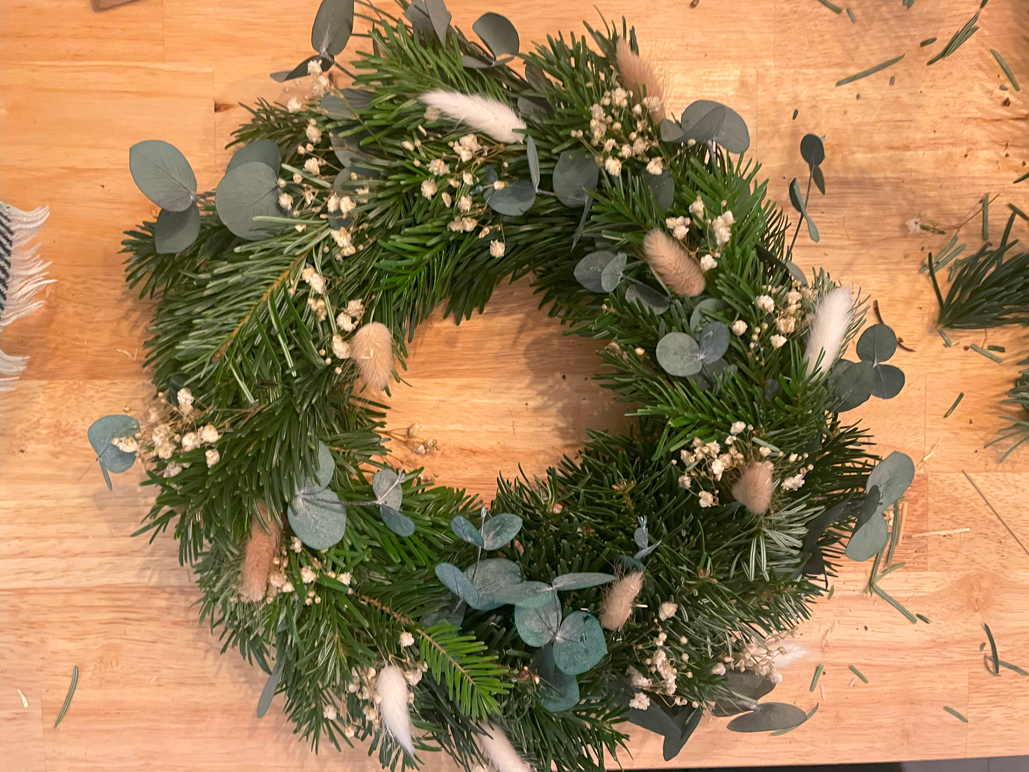 Kranz aus Tannenzweigen mit Eukalyptus und Trockenblumen.