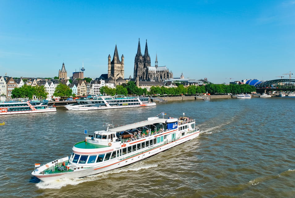 Ein Schiff fährt auf einem Fluss, umgeben von Stadtlandschaft.