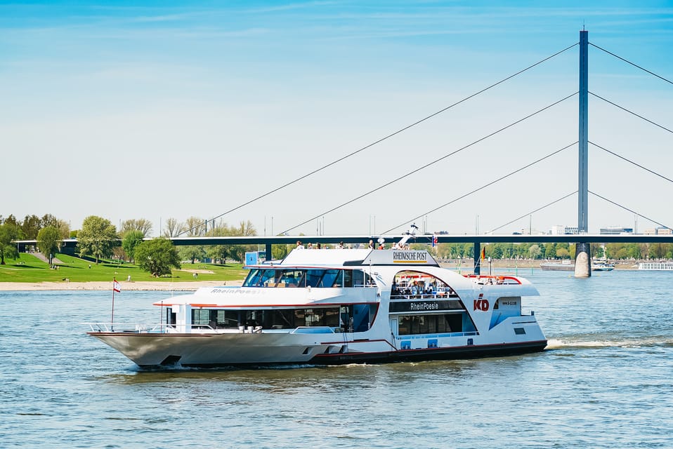 Ein Schiff fährt auf dem Fluss unter einer Brücke entlang.