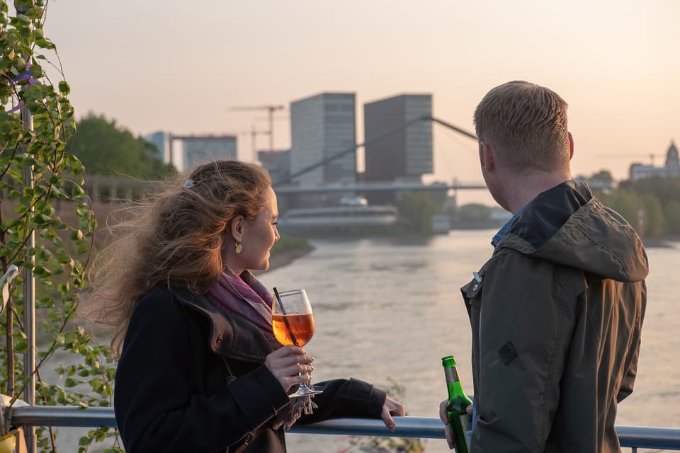 Zwei Personen schauen auf den Fluss bei Sonnenuntergang.