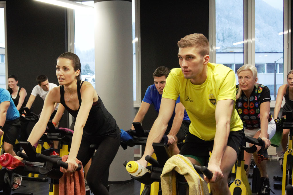Gruppentraining auf Stationärfahrrädern in einem Fitnessstudio.