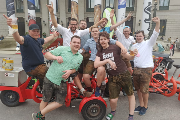 Gruppe feiernder Männer posiert auf einem Fahrrad.
