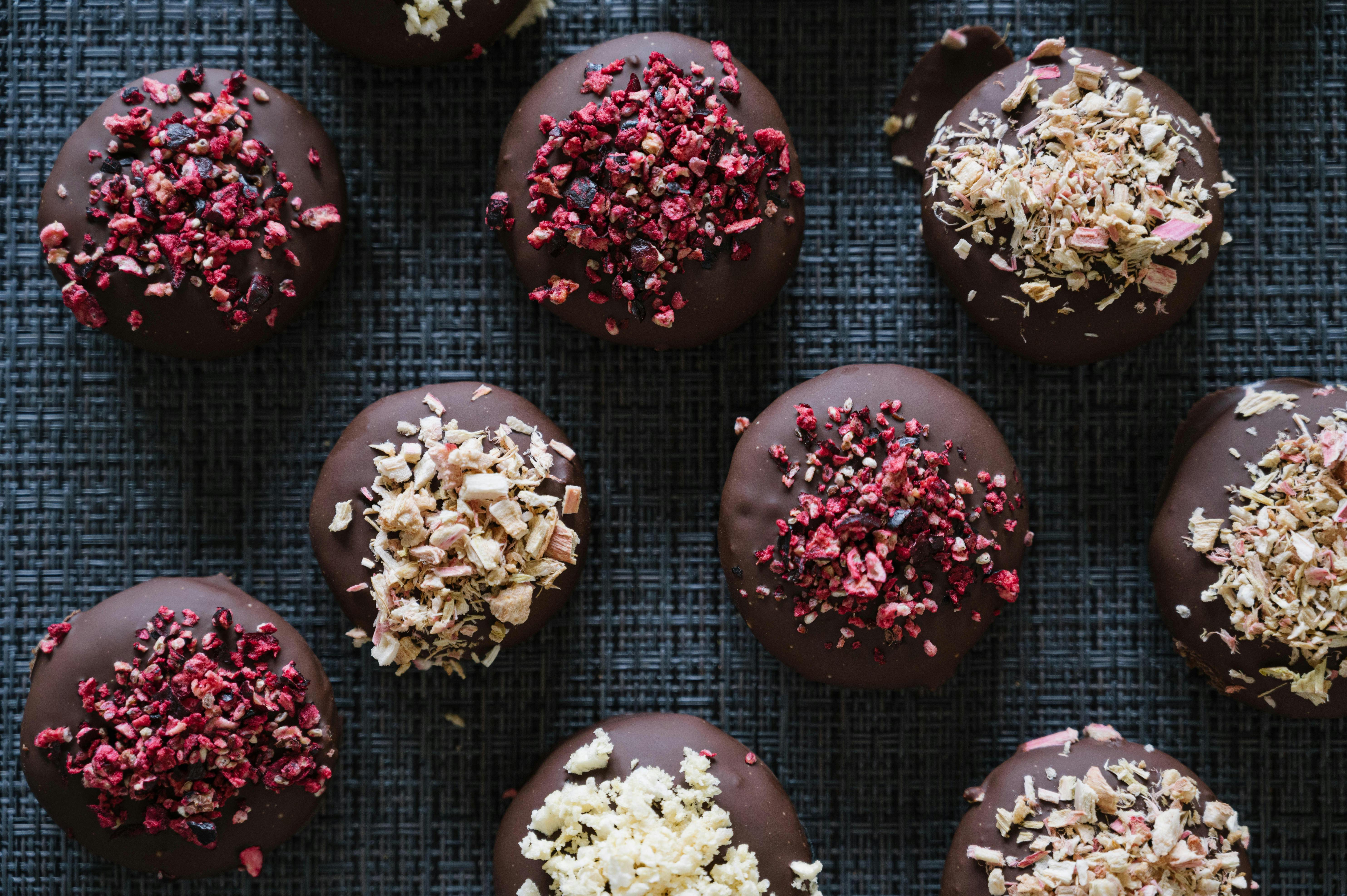 Chocolate chip cookies with colorful toppings on a dark background.
