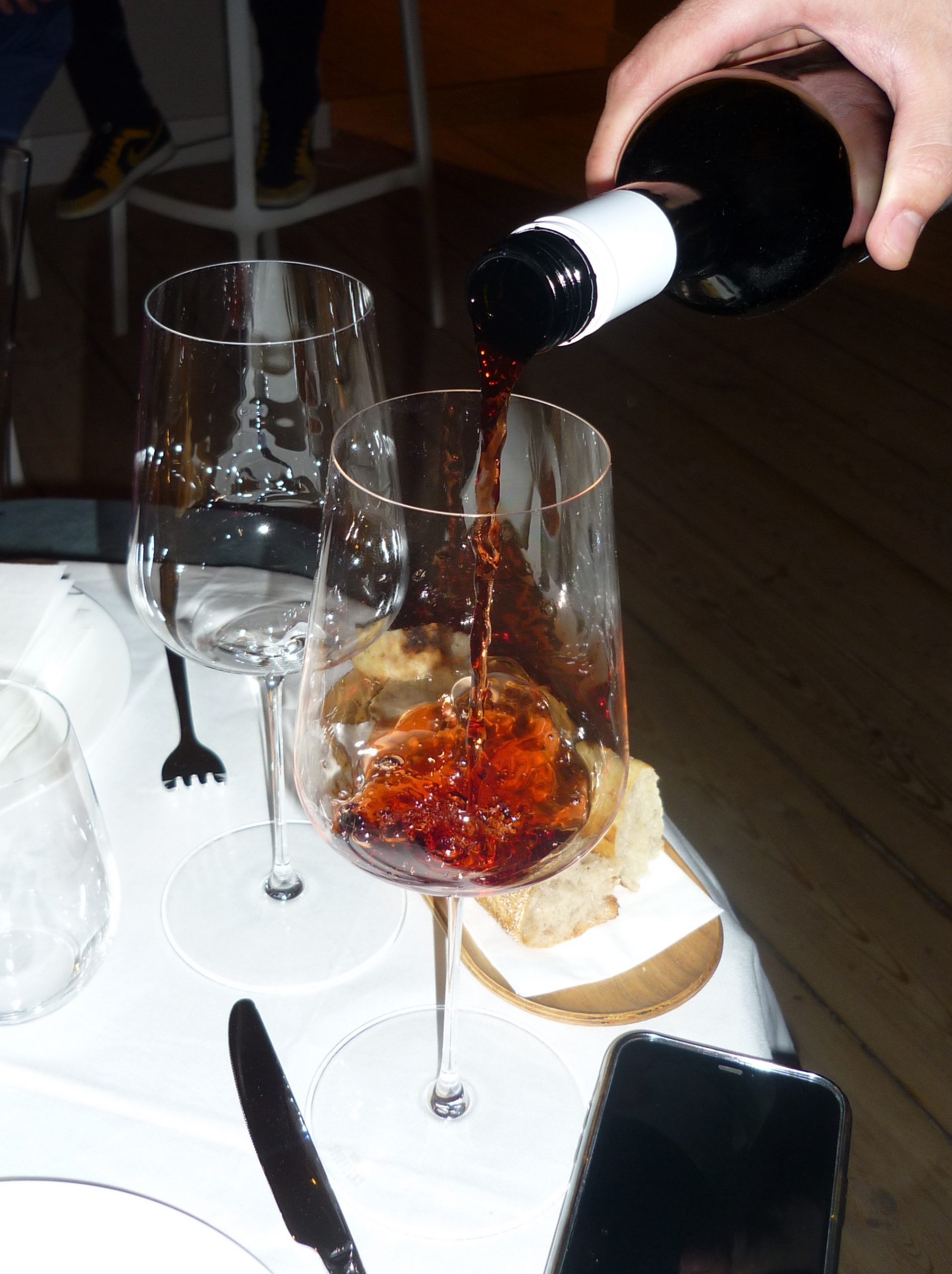 Wine being poured into glass on table.