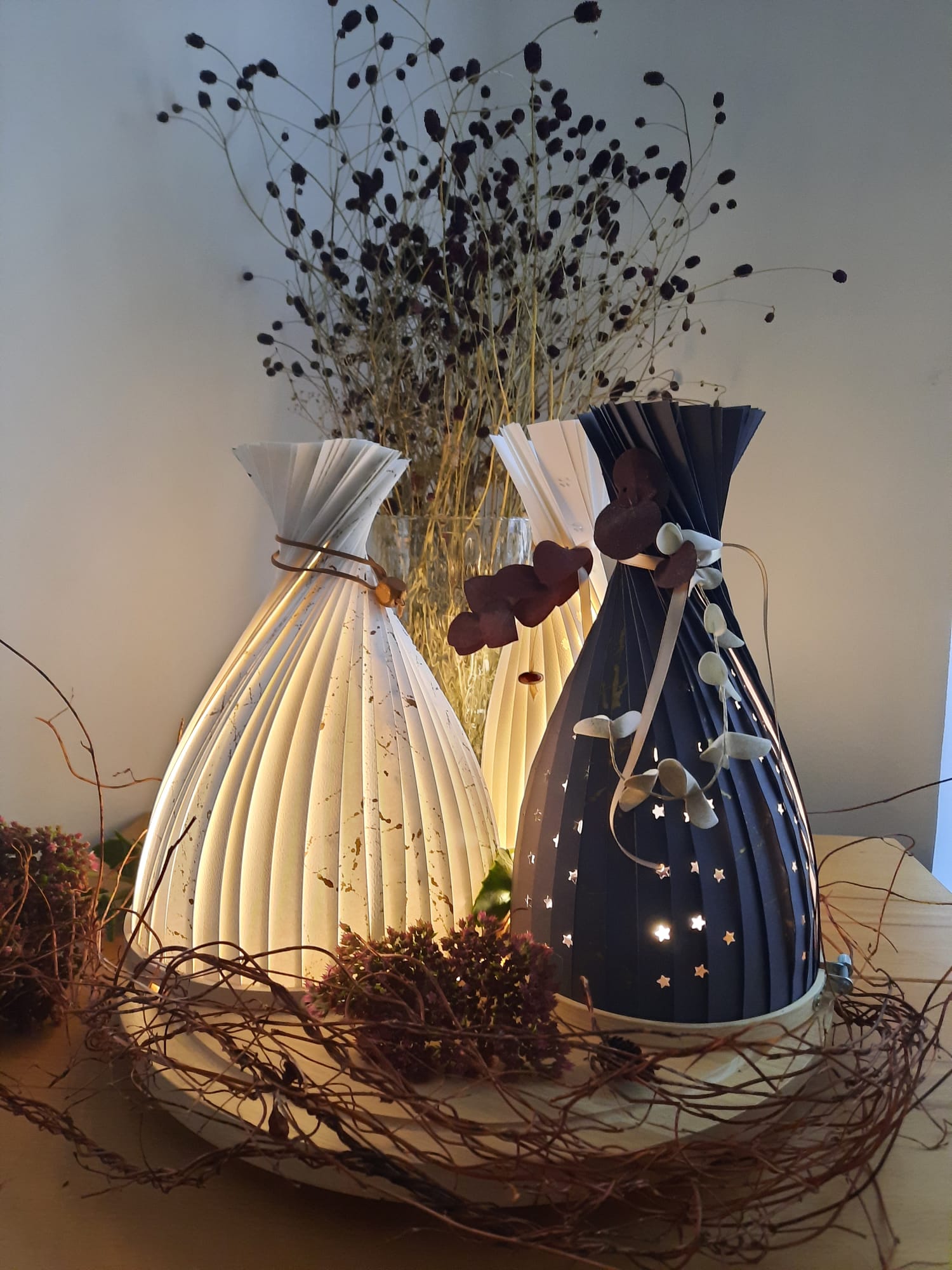 Folded paper lanterns glowing on a table.
