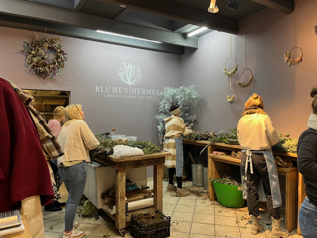 Frauen gestalten Blumenarrangements in einem floralen Geschäft.