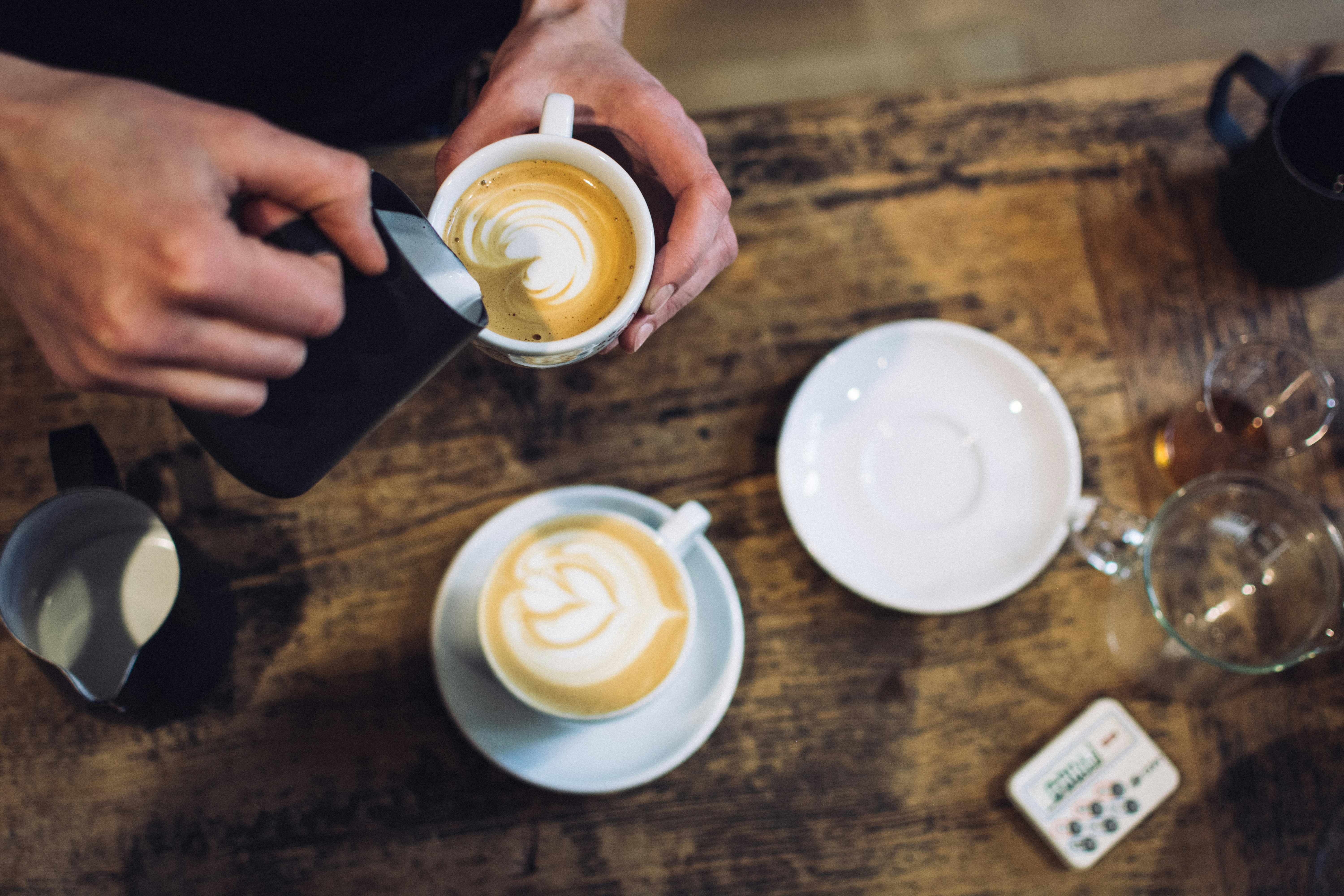 Cup with milk foam is decorated on a table.