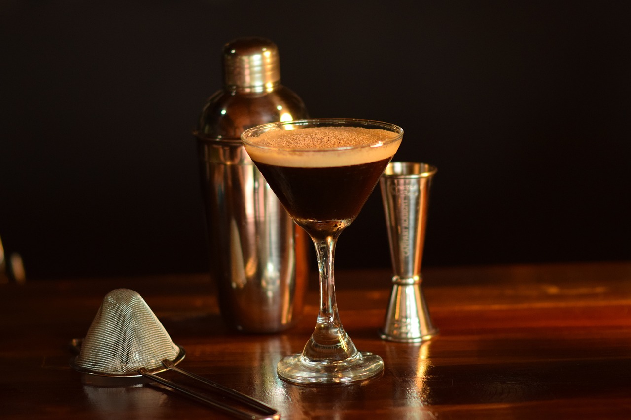 Espresso-Martini und Barutensilien auf einer Holztheke.