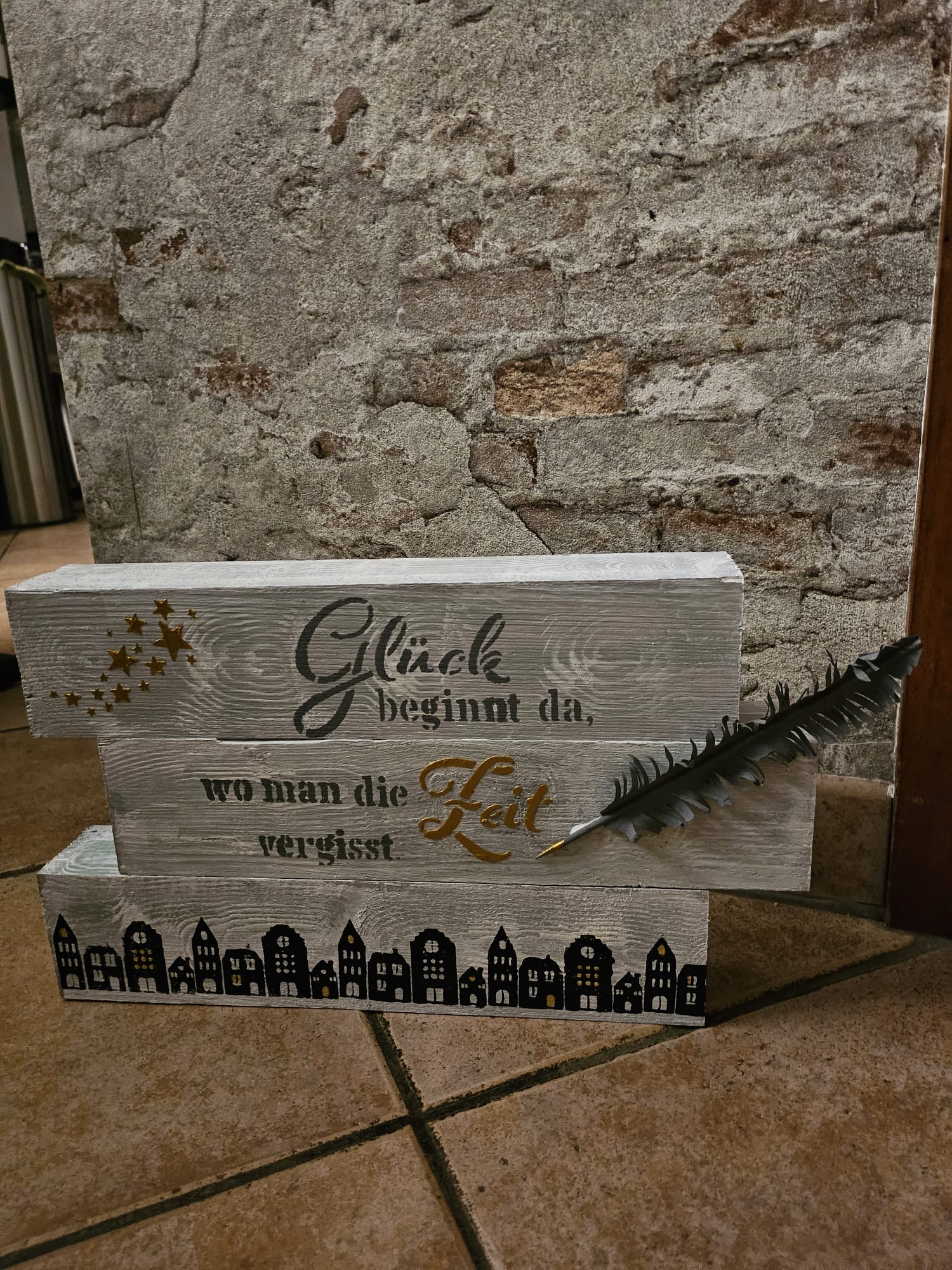 Wooden sign with German text and feather.