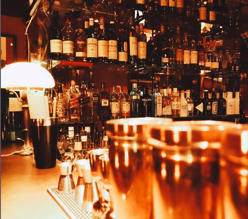 Cocktail bar with bottles and shaker.
