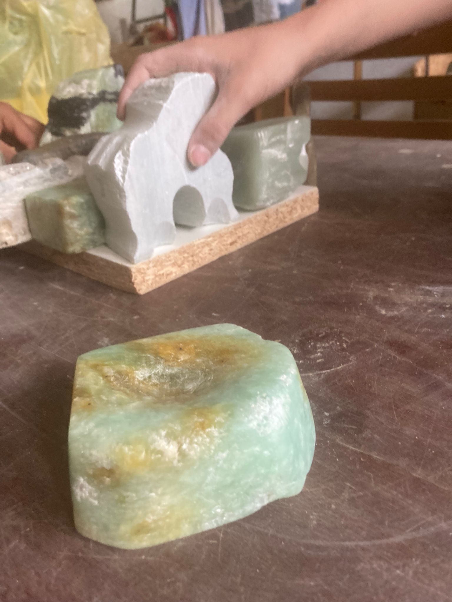 Hand haltend gemeißelten Stein, gedeckter Tisch.