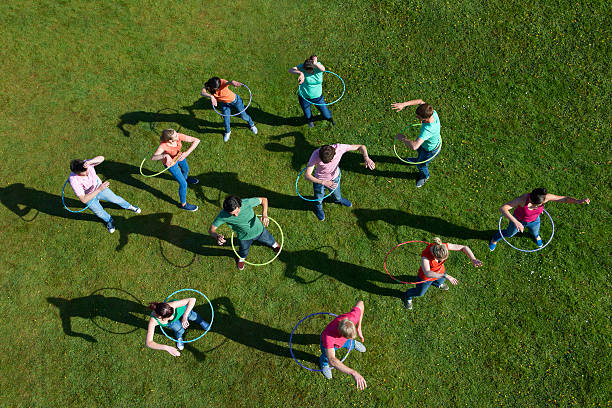 Die Leute hula-hooping auf einer Wiese.
