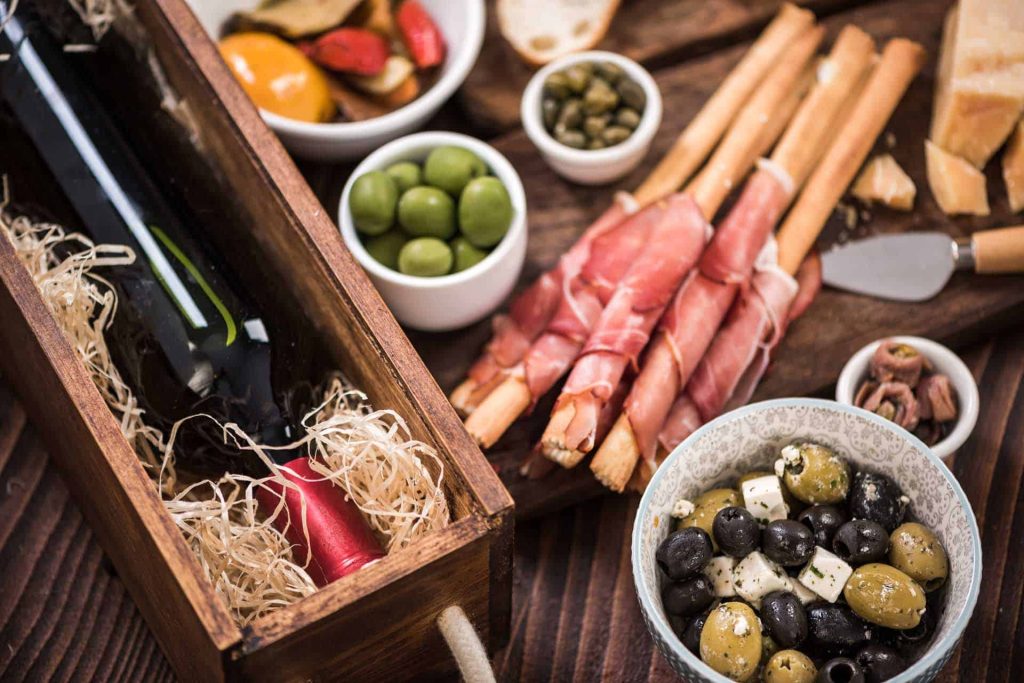 Charcuterie board with wine, olives, and meats.