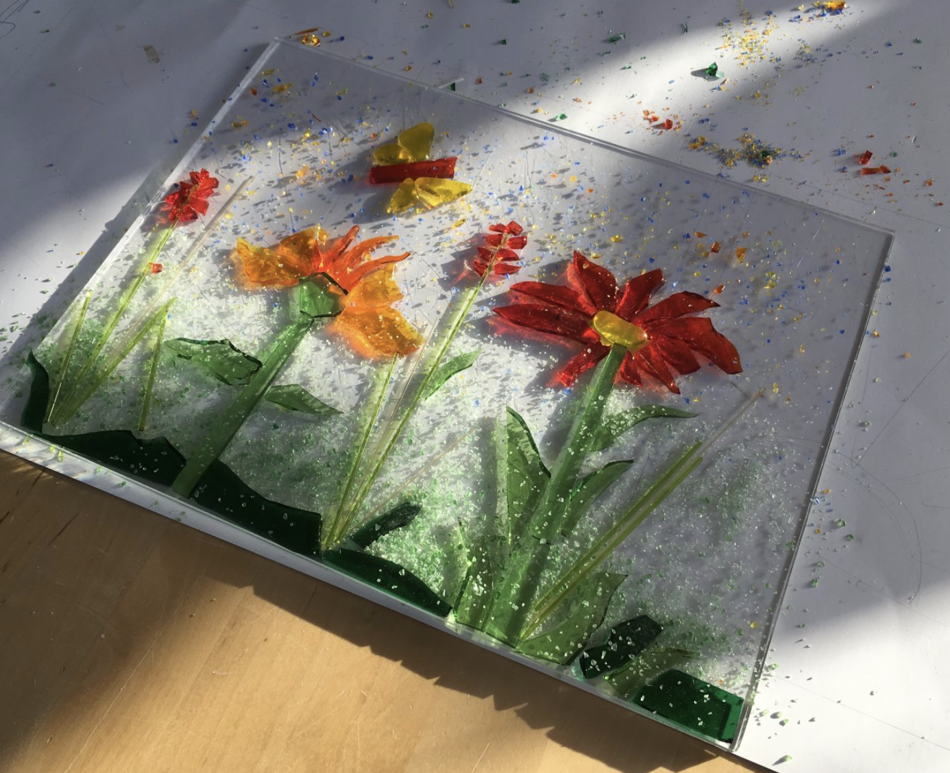 Colorful glass art with flowers and butterfly.
