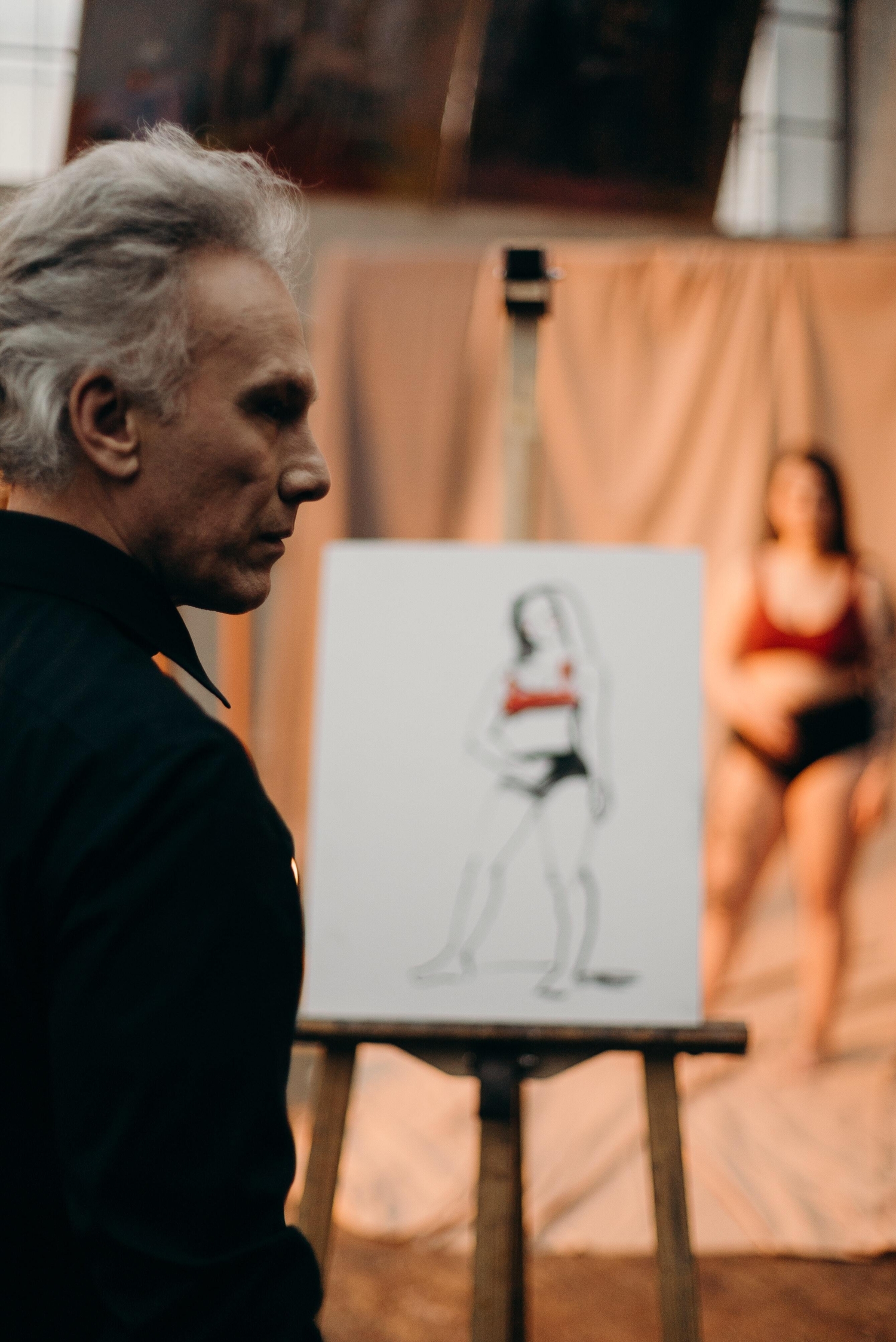 A sketch of a model while a man observes.