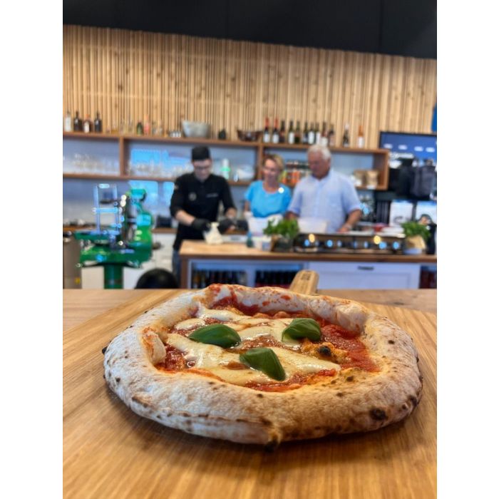 Neapolitan-style pizza with basil on wooden board.