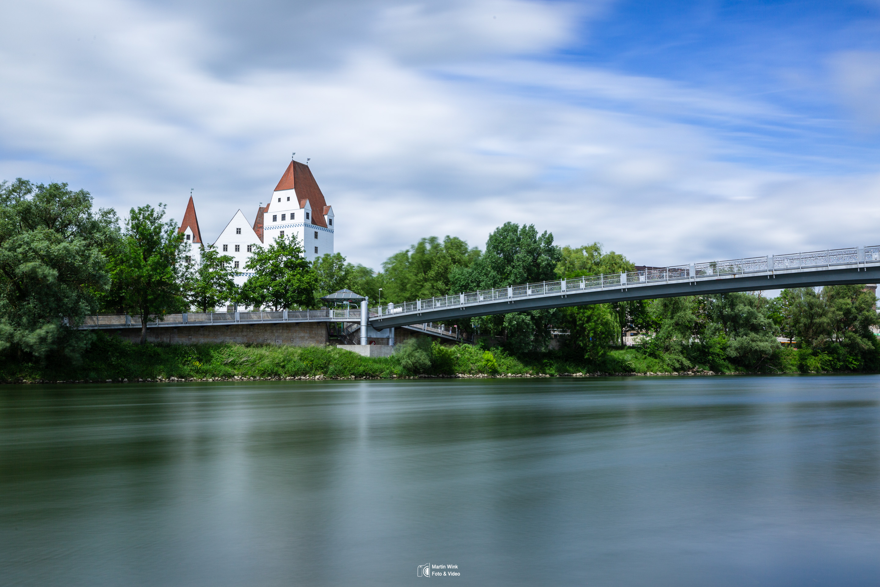 Castle and bridge over calm river.