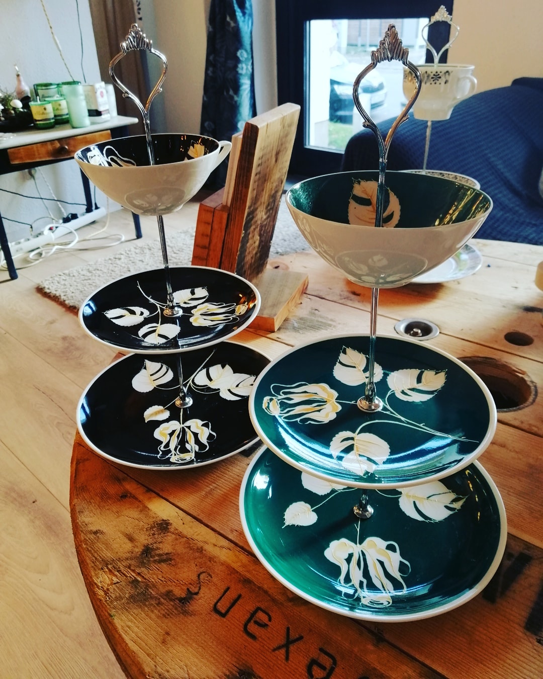 Zweistöckige Tortenständer mit Blumenmuster auf dem Tisch.