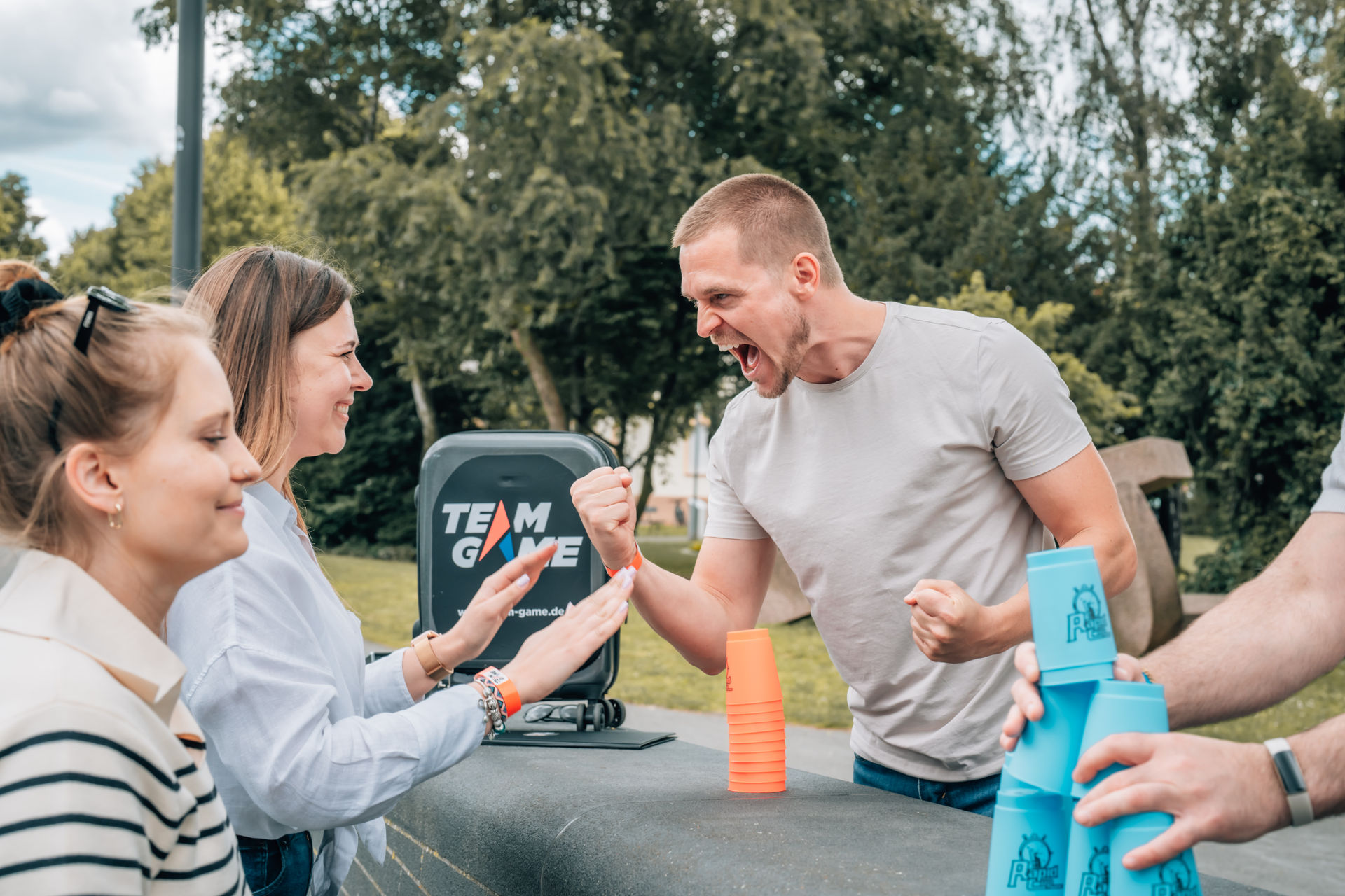 People playing competitive cup stacking outdoors.