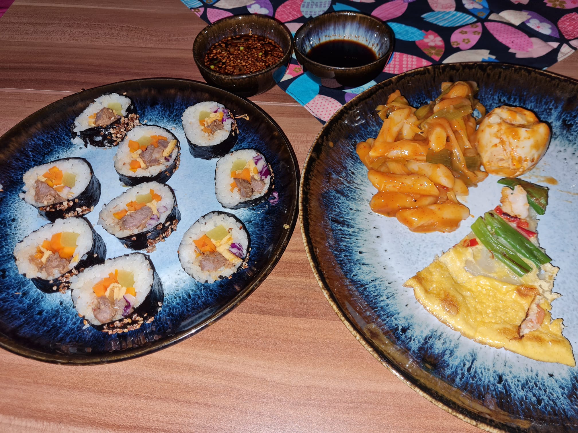Teller mit Kimbap und würzigen Reiskuchen.