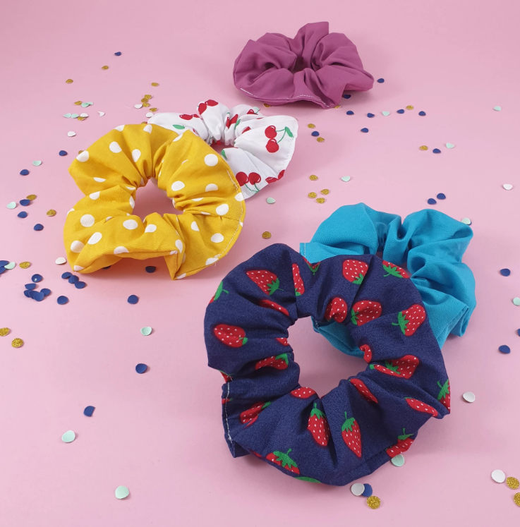 Colorful scrunchies on a pink surface.